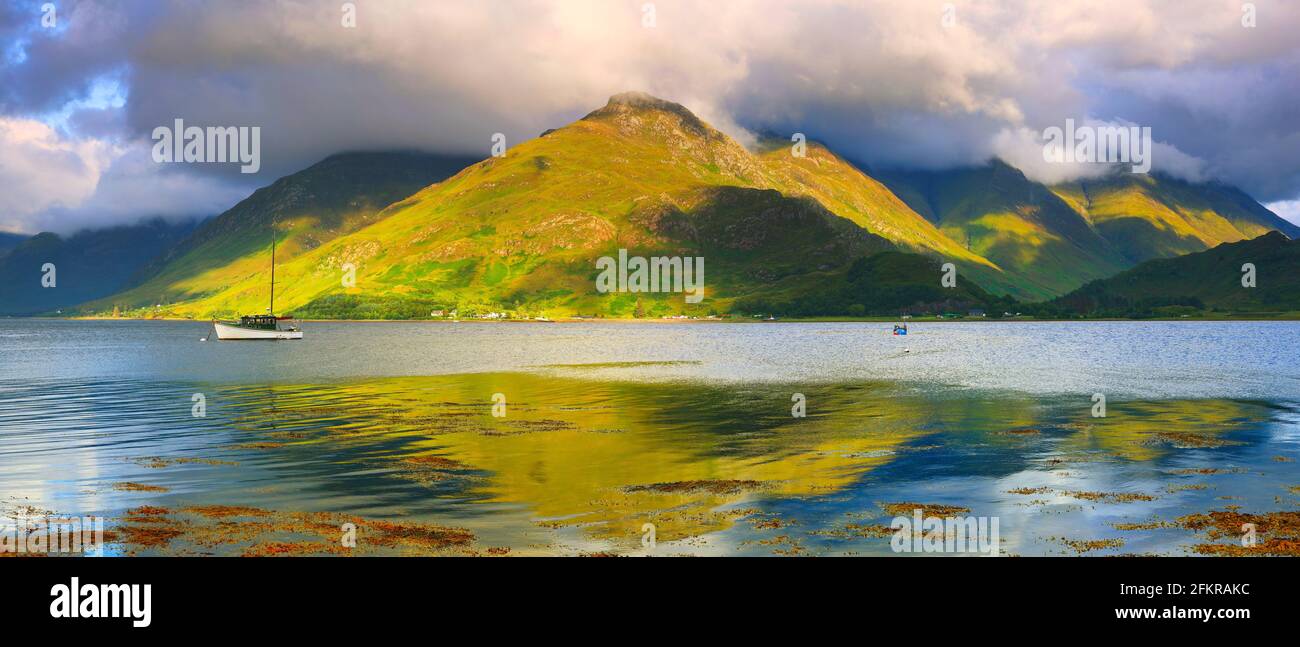 A Lone Sailing Boat on Loch Duich with the Kintail Mountains in the background, West Highlands, Scotland, UK. Stock Photo