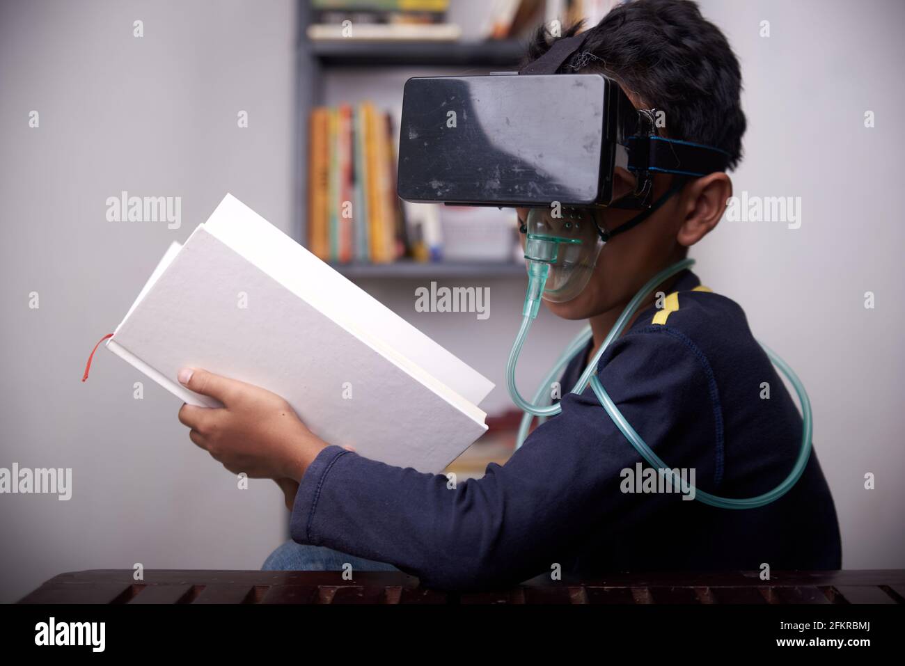 little Boy wearing VR headset and nebulizer mask studying at home quarantine Stock Photo