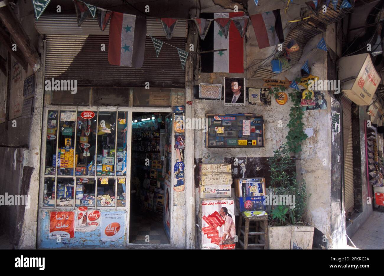 Front shop with Syrian flag hanging and president poster in Al-Hamidiyah Souq, Damascus, Syria Stock Photo