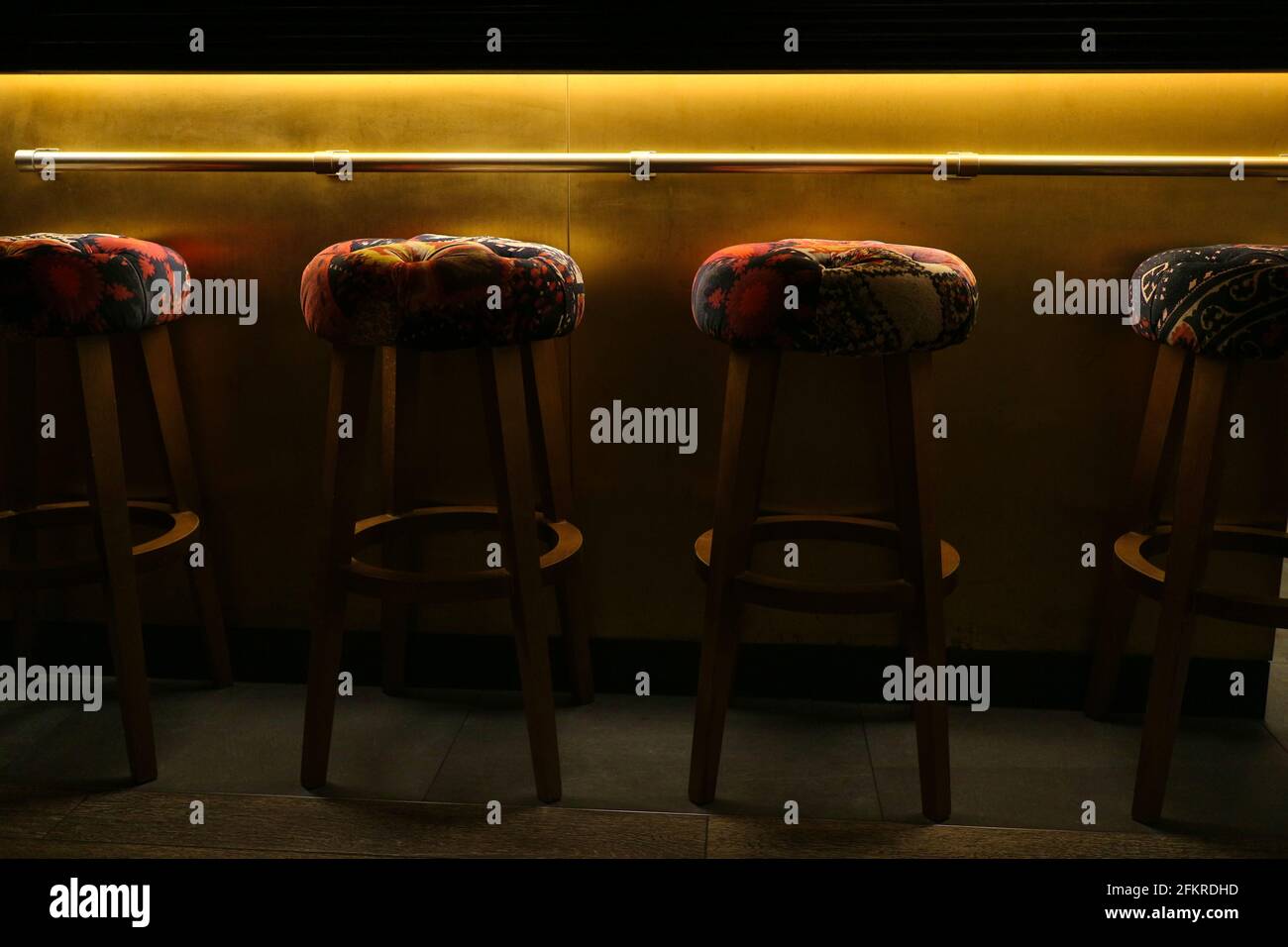 Colourful empty barstools under golden glowing light Stock Photo