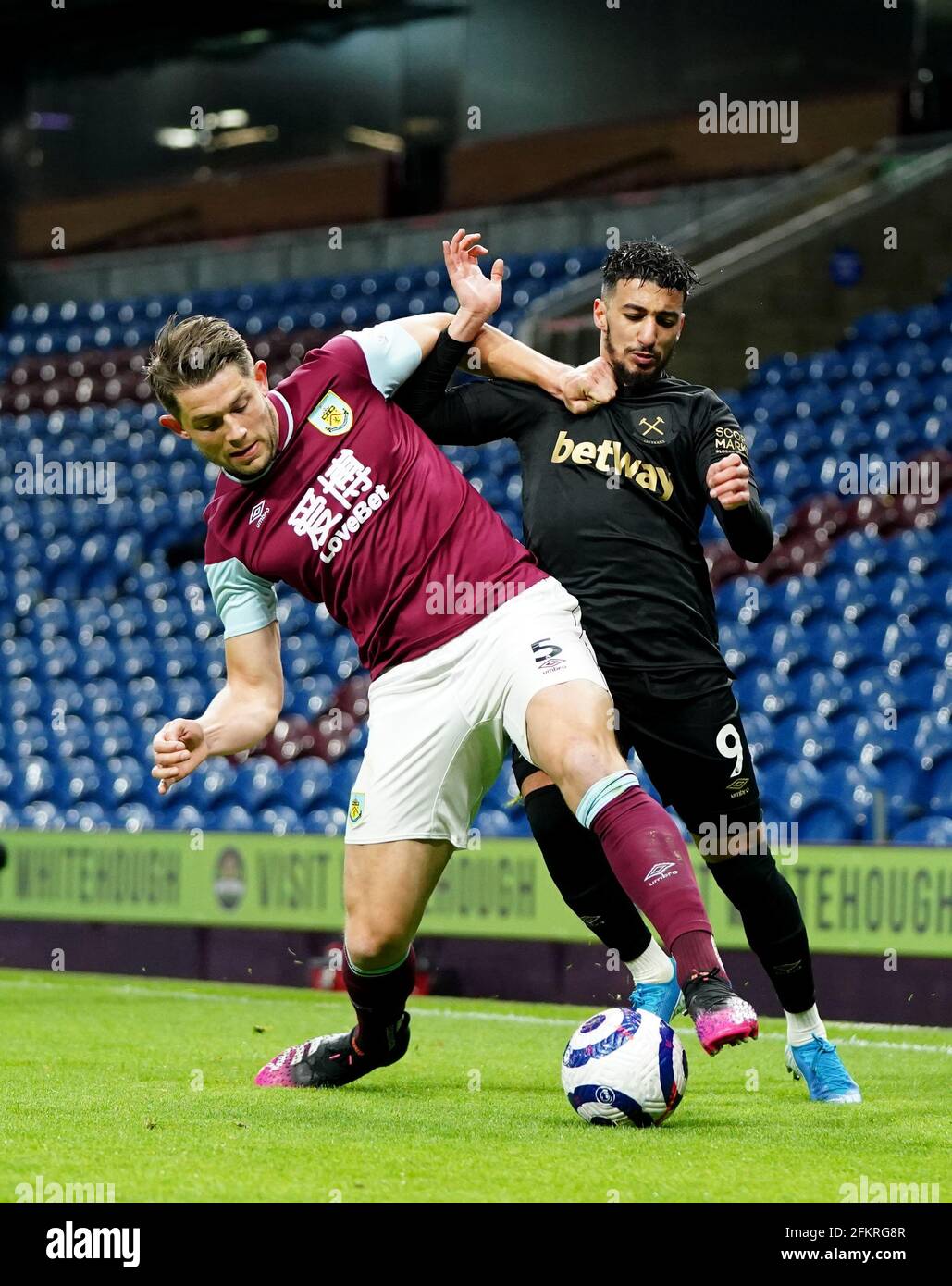 West Ham United's Said Benrahma (right) and Burnley's James Tarkowski (left) battle for the ball during the Premier League match at Tuff Moor, Burnley. Issue date: Monday May 3, 2021. Stock Photo