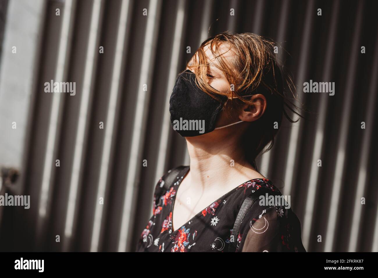 Depressed sad woman screaming and crying under mask for protection from