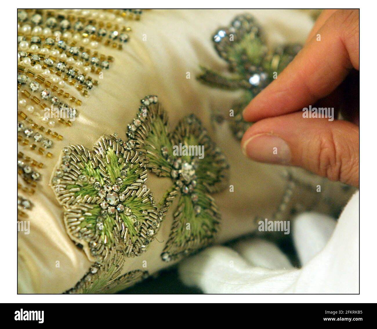 The 50th anniversary of the Coronation of Queen Elizabeth ll will be celebrated at this year's Summer Opening of Buckingham Palace State Rooms with the display of Her Majesty's magnificent Coronation Dress, seen being prepared by Janet Wood, senior textile conservator at Hampton Court Palace. An extra Shamrock (four leaf clover) added by sir Norman Hartwell the designer of the dress......pic David Sandison 30/5/2003 Stock Photo
