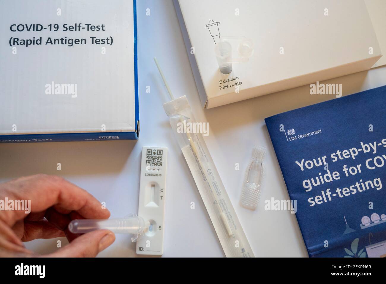 Contents of the NHS Covid19 rapid antigen selftest kit; a woman