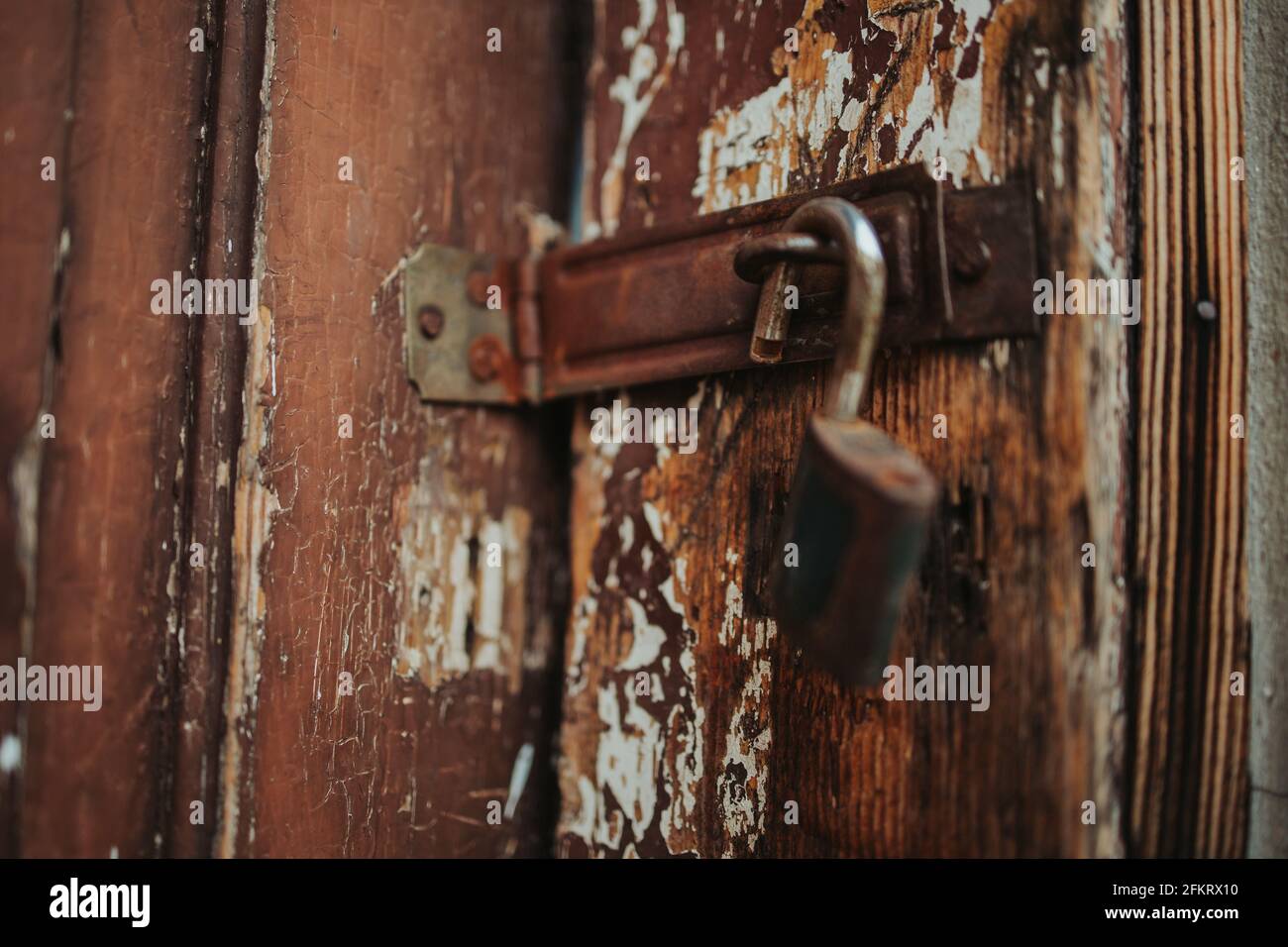 Closeup shot of a rusty padlock hanging on an old wooden door Stock ...