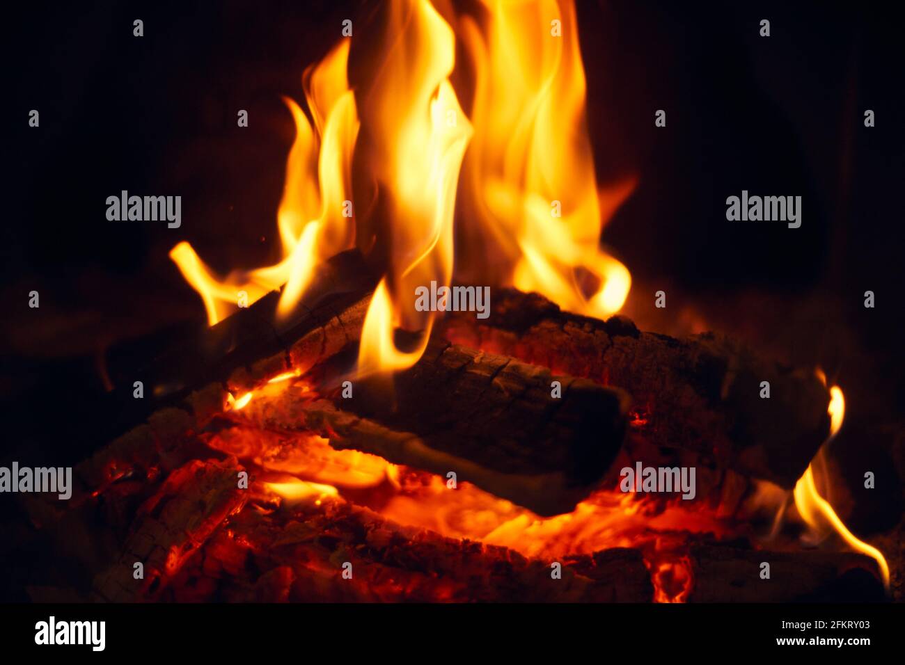 A fire burns in a fireplace, Fire to keep warm. Logs burning in Stock
