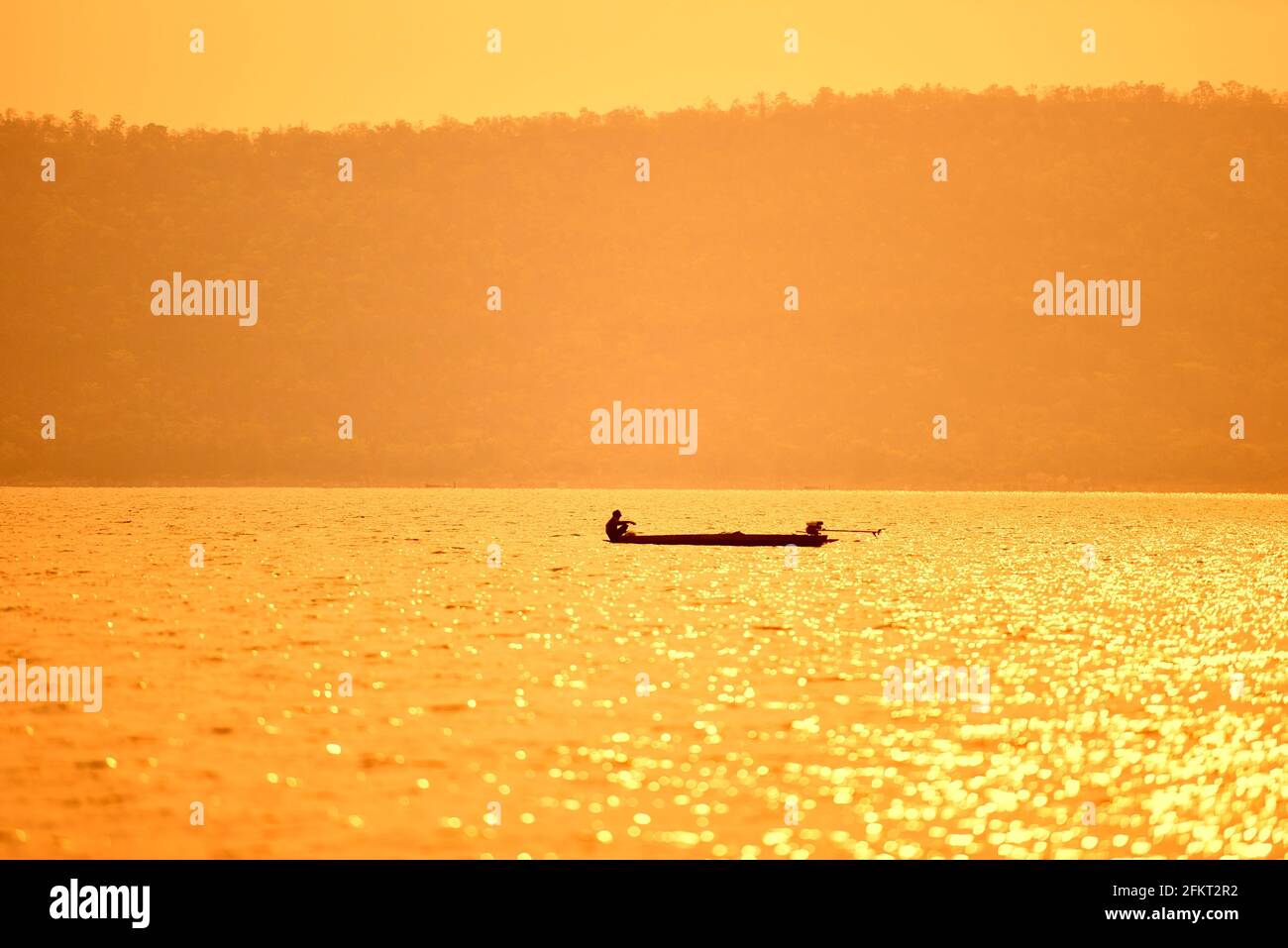 Asia fisherman on wooden boat sunset or sunrise in the river ...