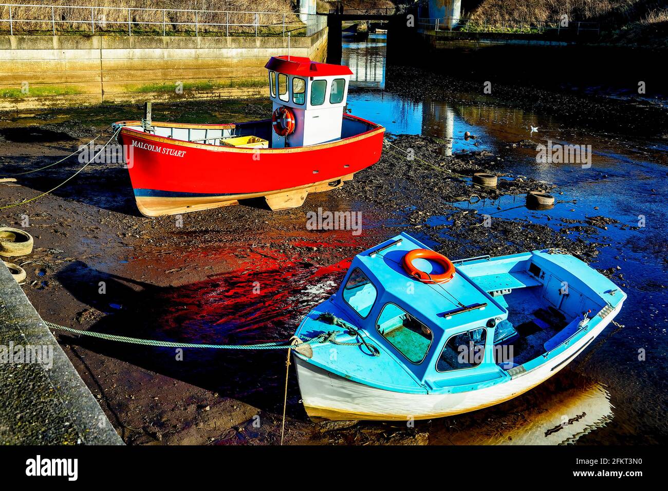 Fishing boats in the harbor at low tide Stock Photo - Alamy