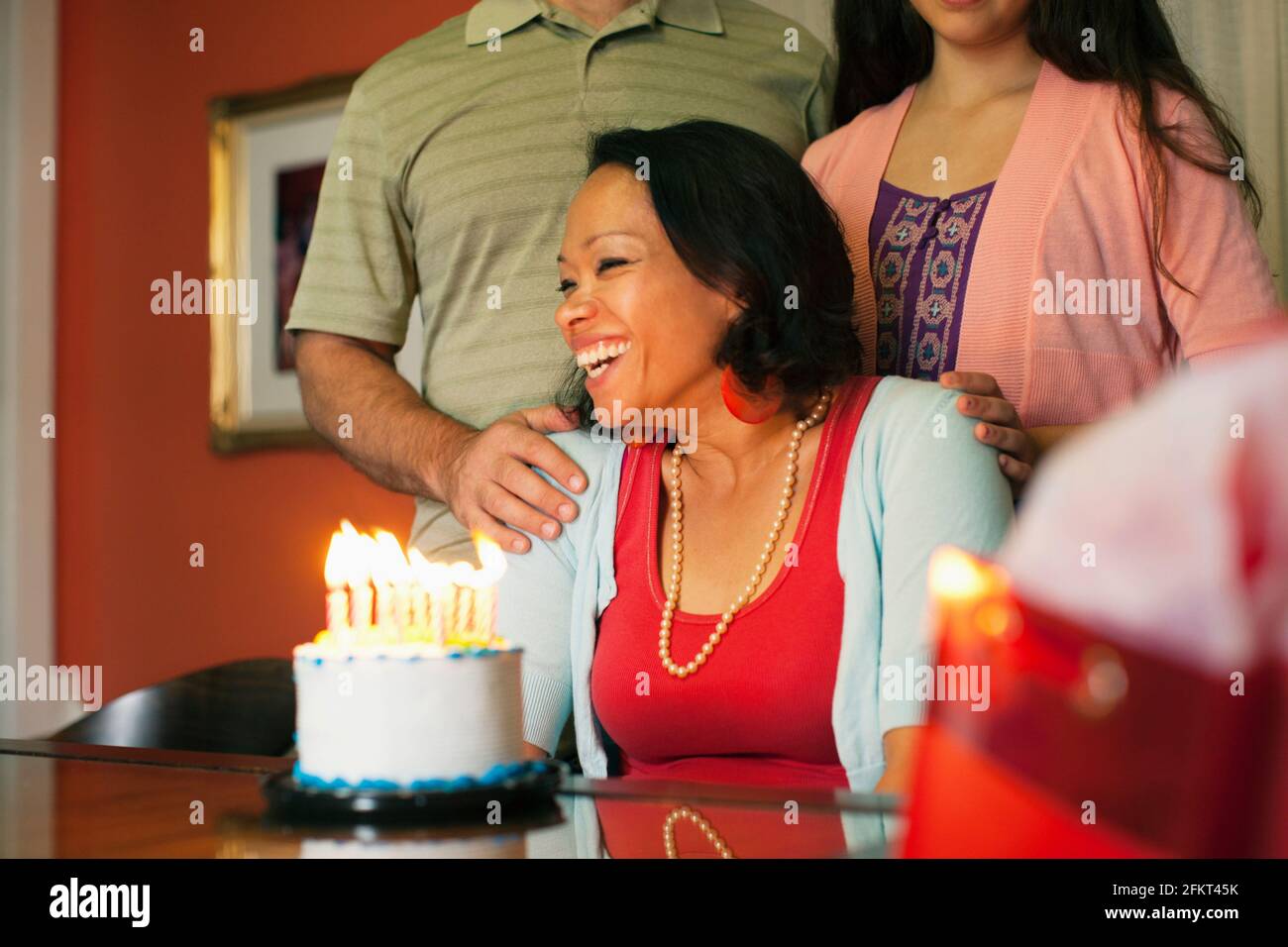 Woman smiling over birthday cake Stock Photo
