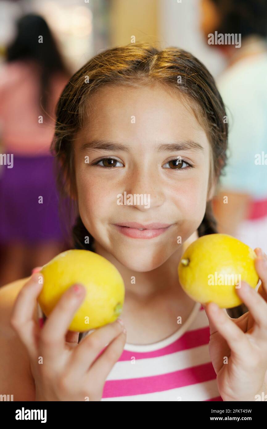 Girl holding two lemons Stock Photo Alamy