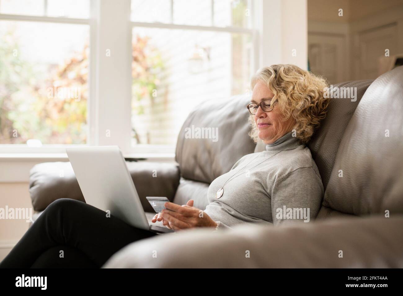 Senior woman shopping online on laptop Stock Photo