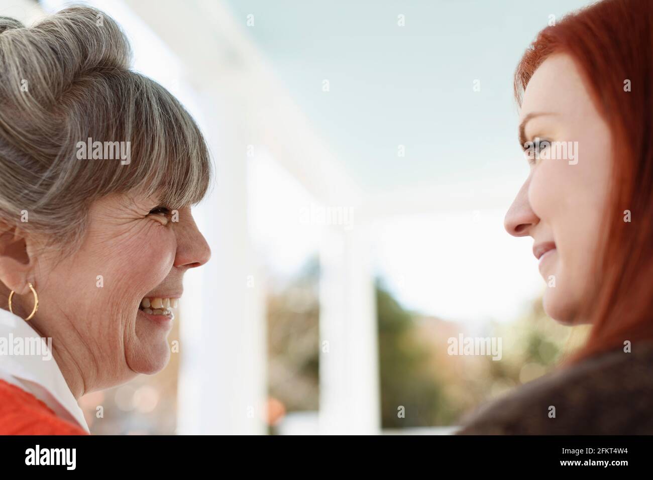 Close up of senior woman and adult daughter laughing on porch Stock Photo