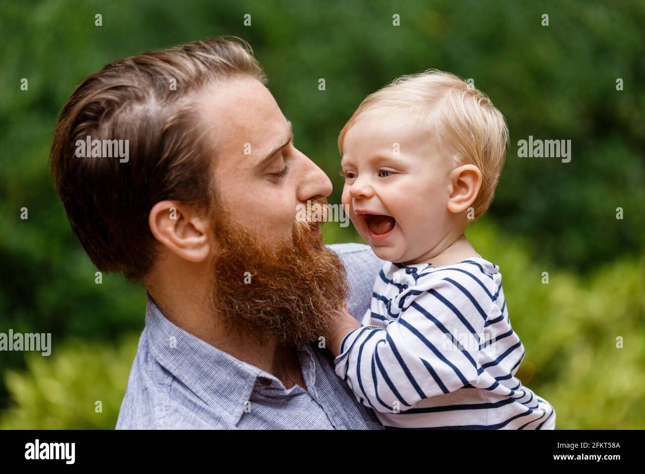 Portrait of father and baby girl, outdoors, laughing Stock Photo