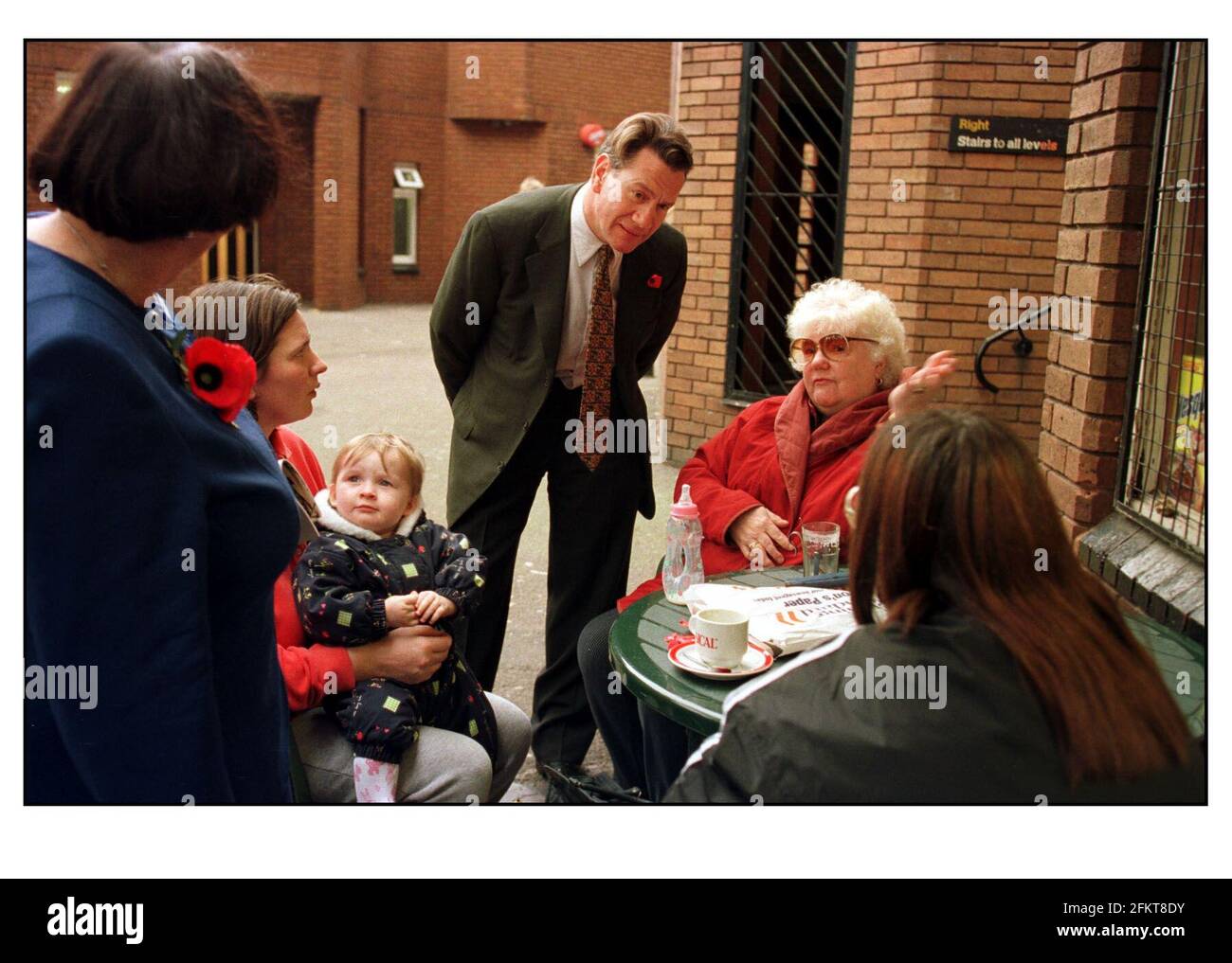 MICHAEL PORTILLO CHELSEA AND WESTMINSTER BY ELECTION NOV99 DOREEN CONDON (70) IN AN UNCOMFORTABLE MEETING WITH MICHAEL PORTILLO ON HIS SHORT TOUR OF THE WORLDS END ESTATE IN CHELSEA. OTHER WOMEN AT THE TABLE ARE TERESA SMITH (JACKET HAS STRIPES) Stock Photo