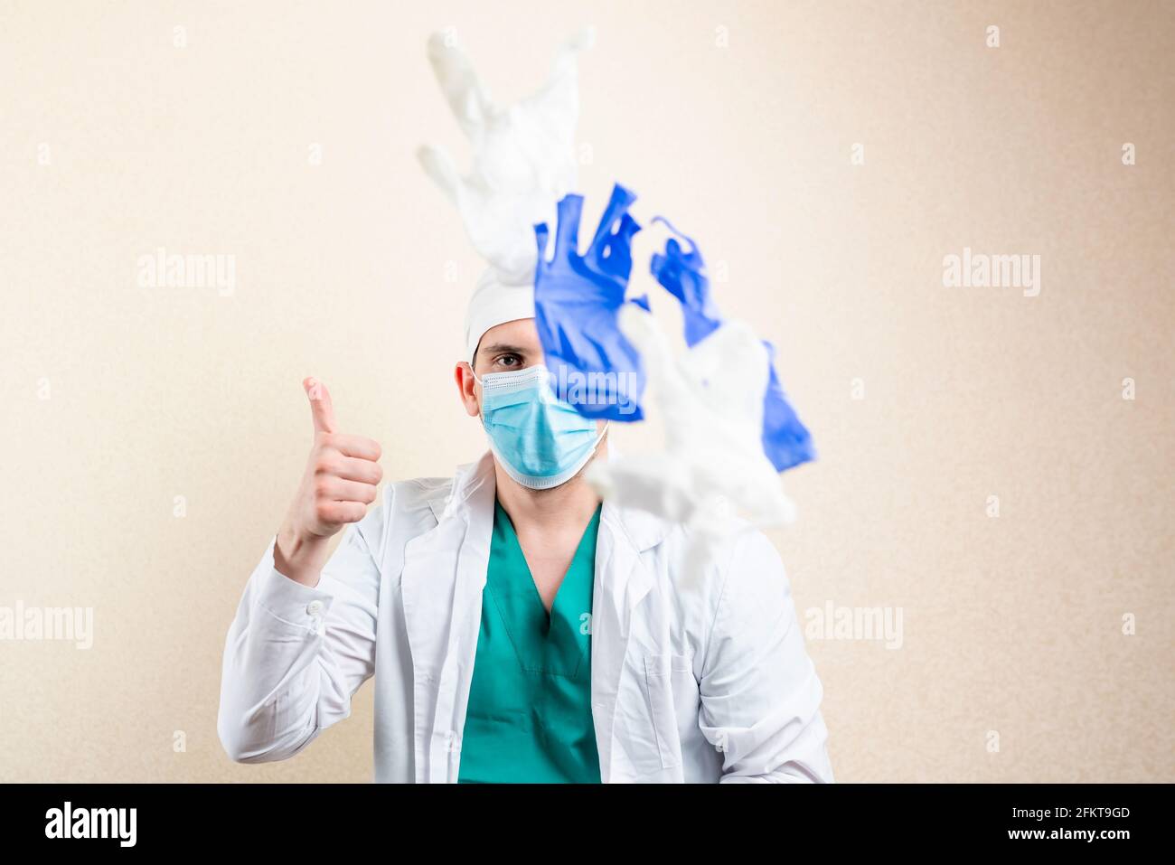 The doctor plays and throws up his gloves. On a light background Stock