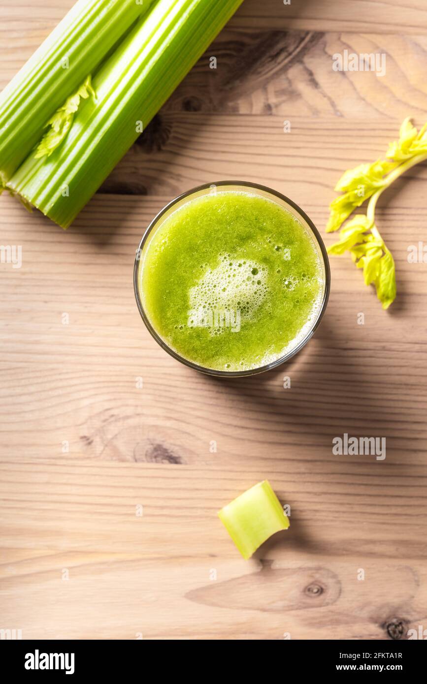 Celery juice in glasses. Fresh squeezed detox green juice and bunch of