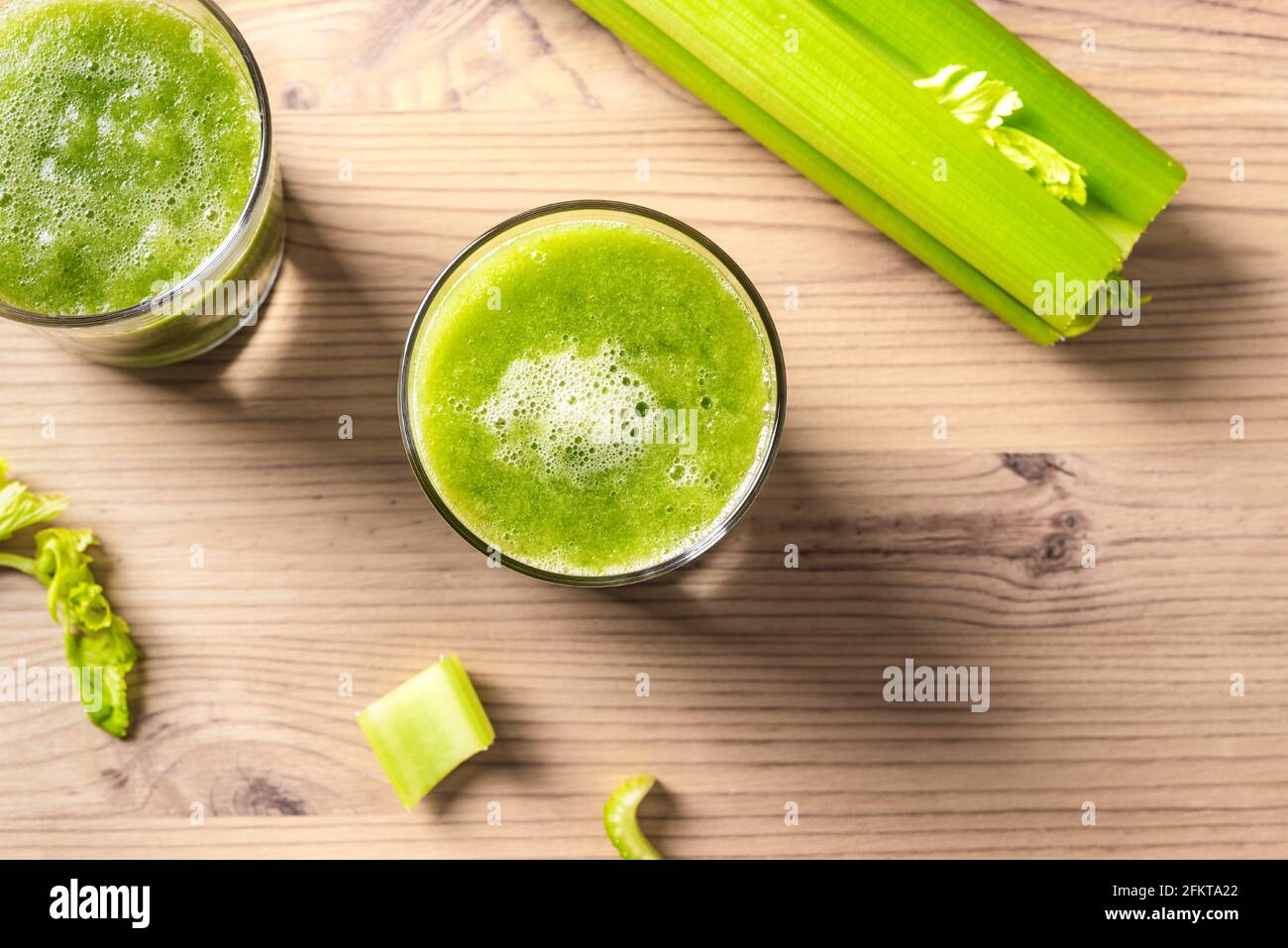 Celery juice in glasses. Fresh squeezed detox green juice and bunch of