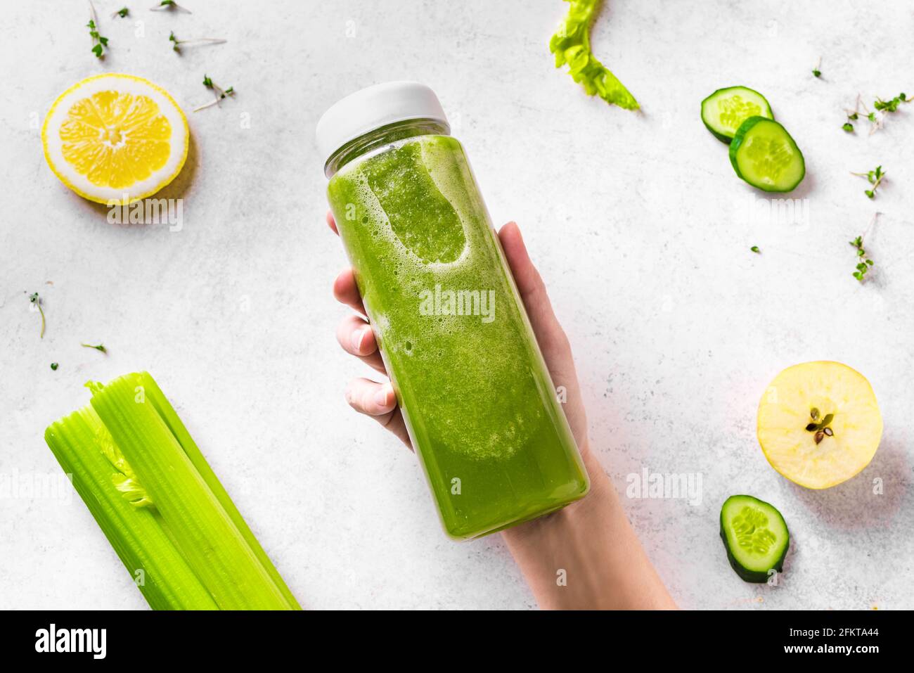 https://c8.alamy.com/comp/2FKTA44/green-smoothie-plastic-bottle-in-female-hand-and-ingredients-on-white-top-view-fresh-raw-detox-smoothie-or-green-juice-for-healthy-eating-2FKTA44.jpg