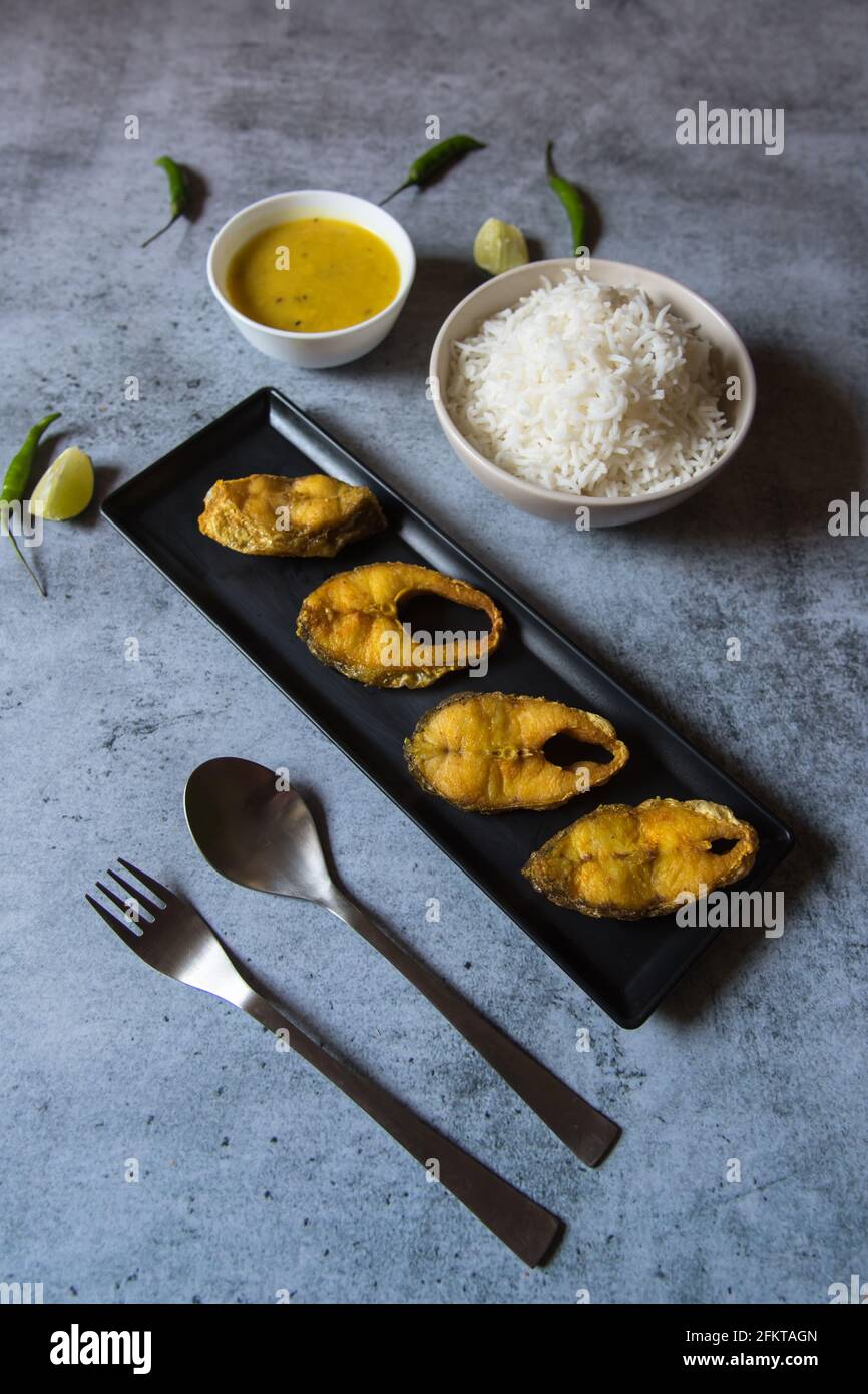 Bengali style lunch menu fried fish served with steamed rice and pulses