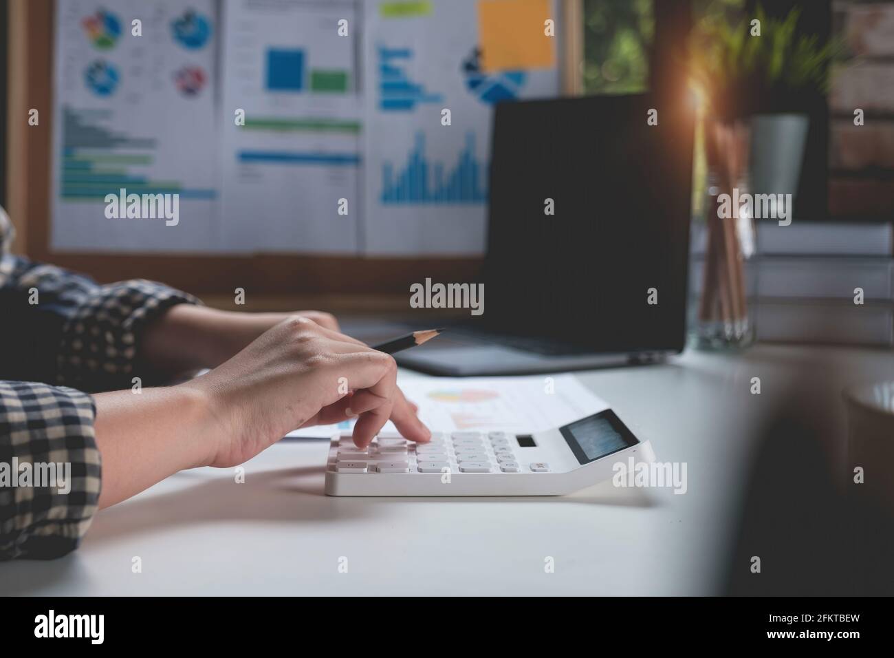 Business woman hand using calculating her bank savings account, account or saving money or insurance concept. Stock Photo