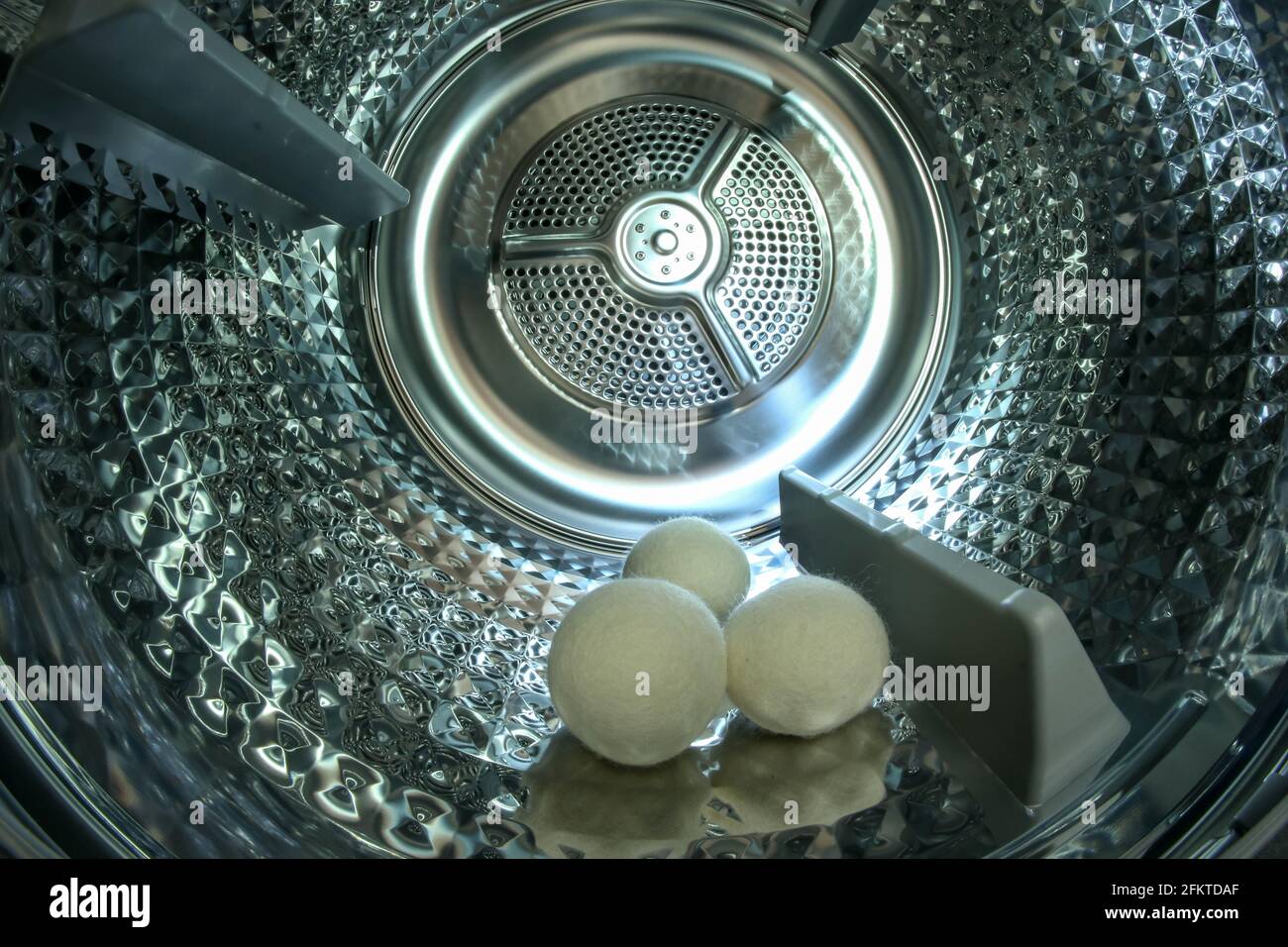 The look inside the shiny metal drum of the modern dryer with three
