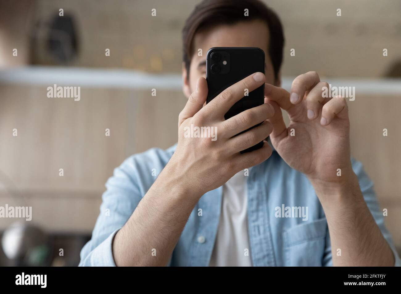 Close up cropped of young man using smartphone, browsing apps Stock Photo