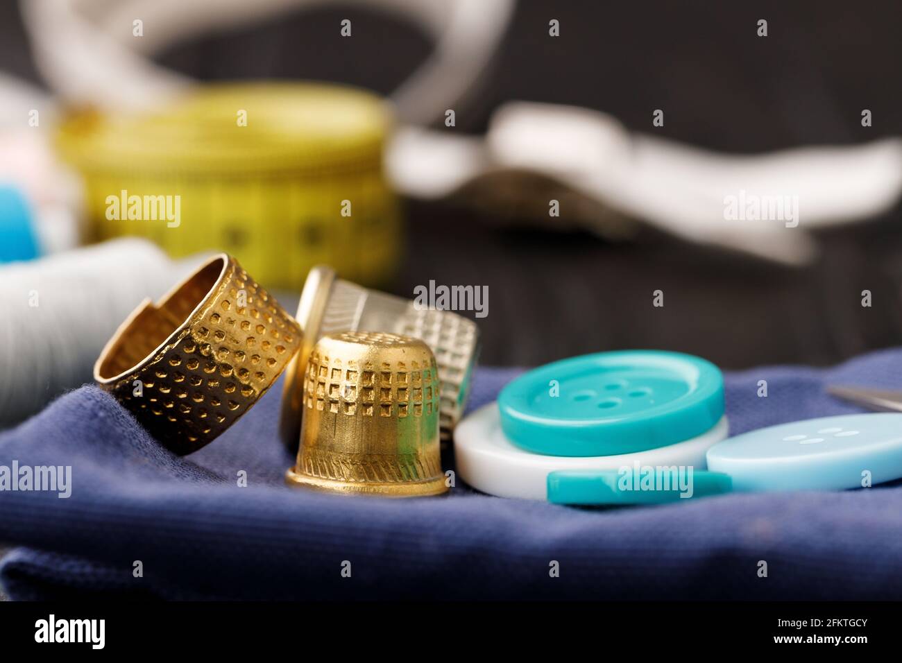 Thimble and measuring tape on wooden table Stock Photo - Alamy