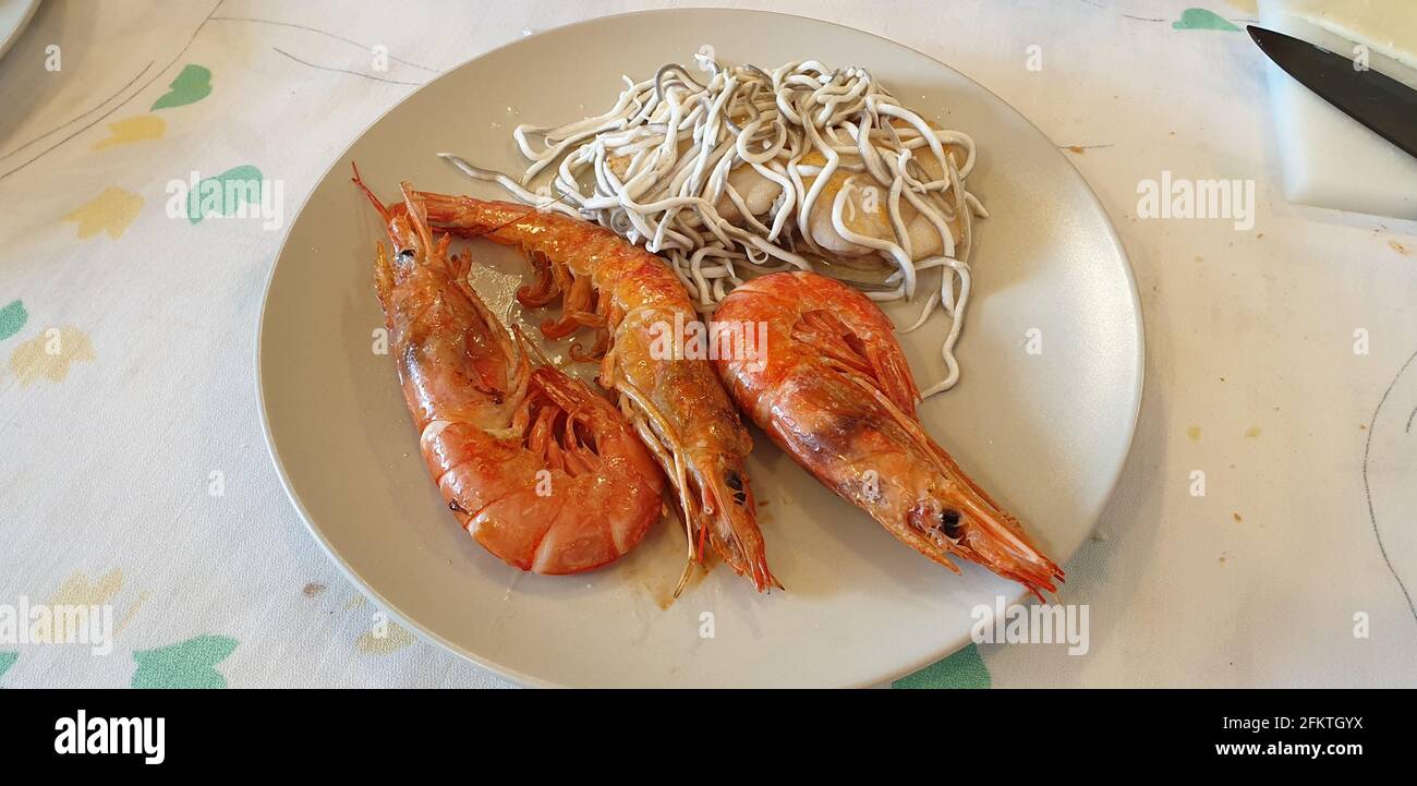 Cooked hake with baby eels and shrimp, a low-fat dish that is ideal after Christmas excesses and is very rich. Bon Appetite Stock Photo