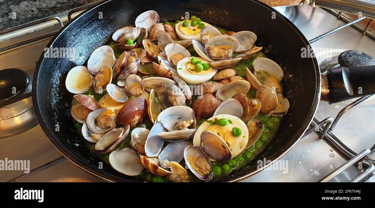 Delicious and easy peas with clams. A different first course, a healthy and delicious recipe. Stock Photo