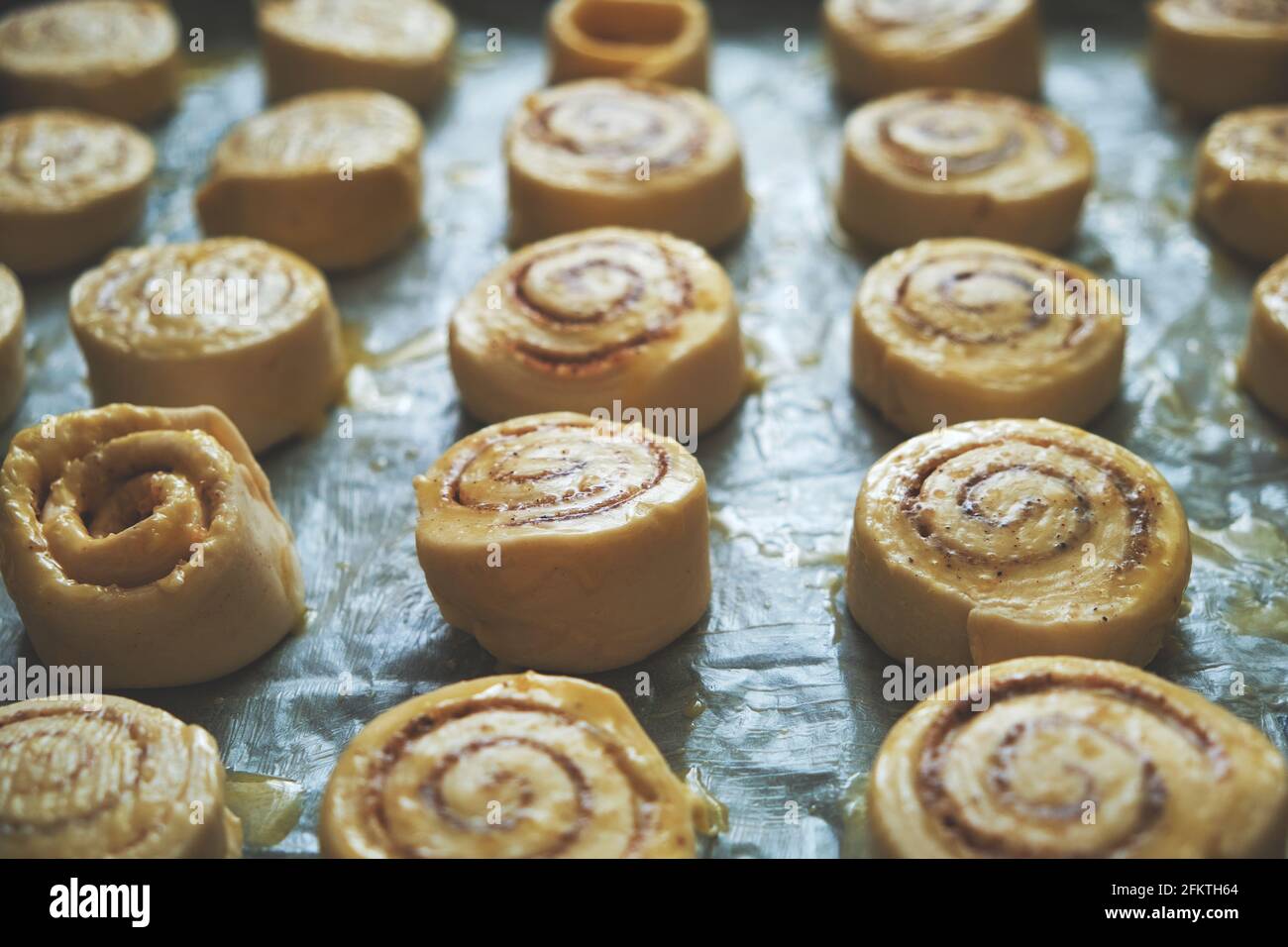 Blanks for baking cinnamon rolls on baking sheet with parchment paper Stock Photo