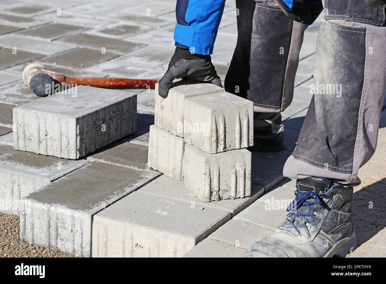 Construction worker lay paving stones. Stock Photo