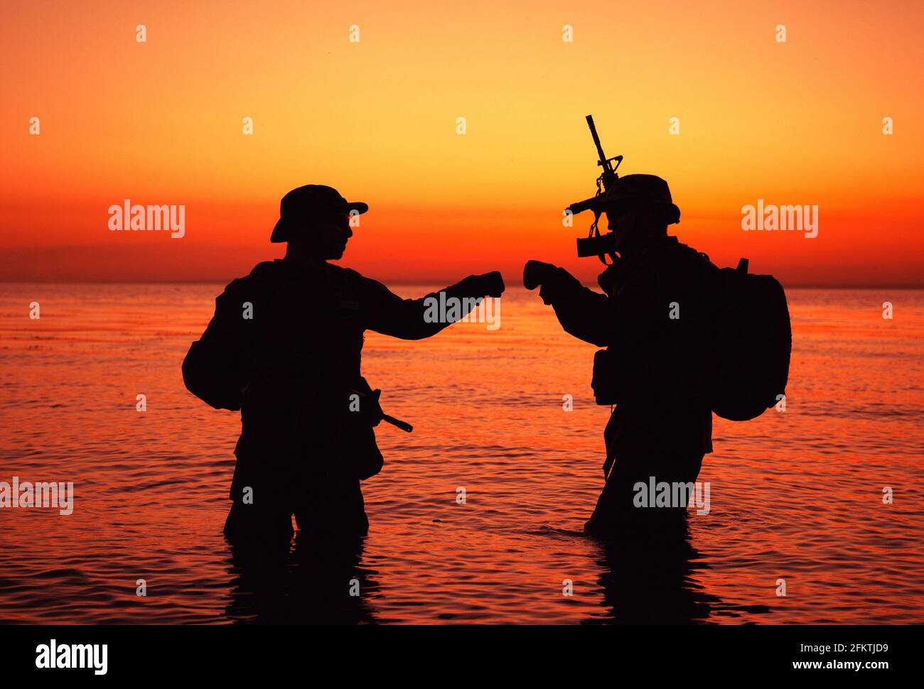 Army special operations forces soldiers, commando fighters doing fist dump  gesture while standing knee-deep in water. Two Marines shooters or coast  Stock Photo - Alamy