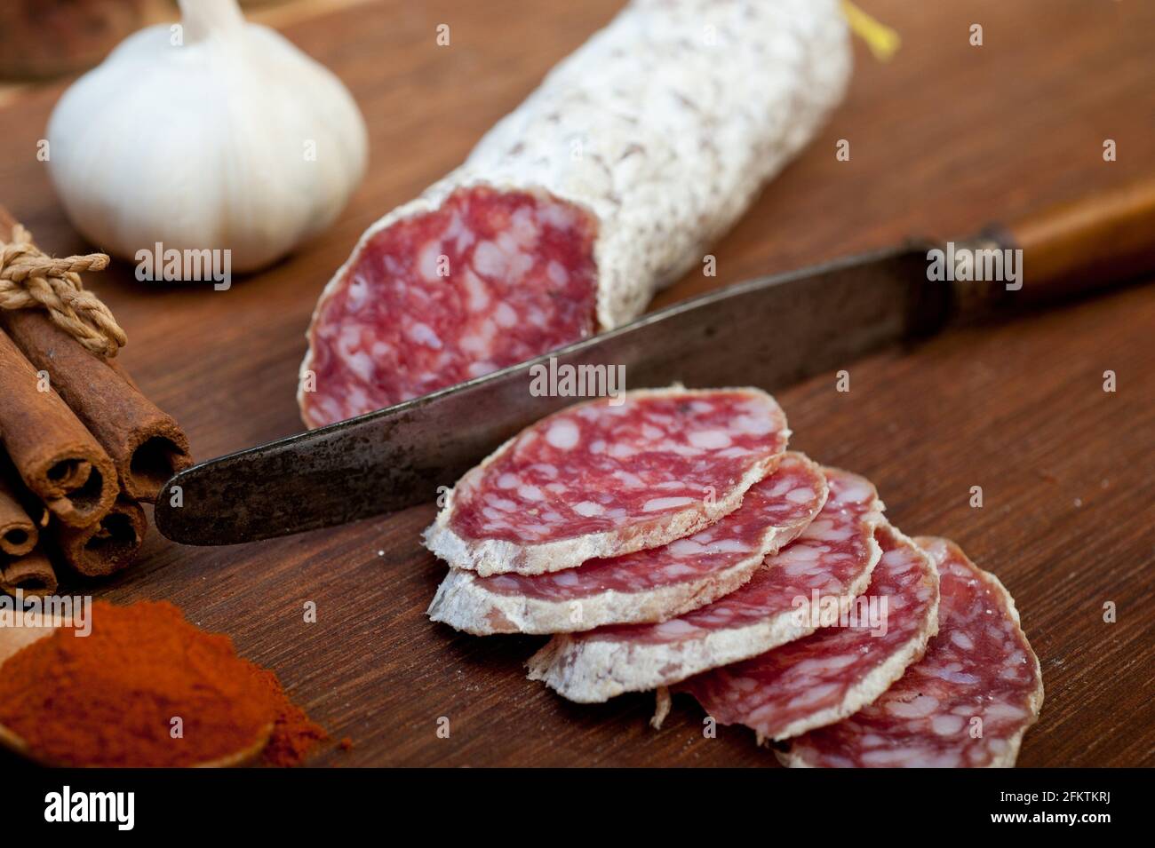traditional Italian salame cured sausage sliced on a wood board Stock