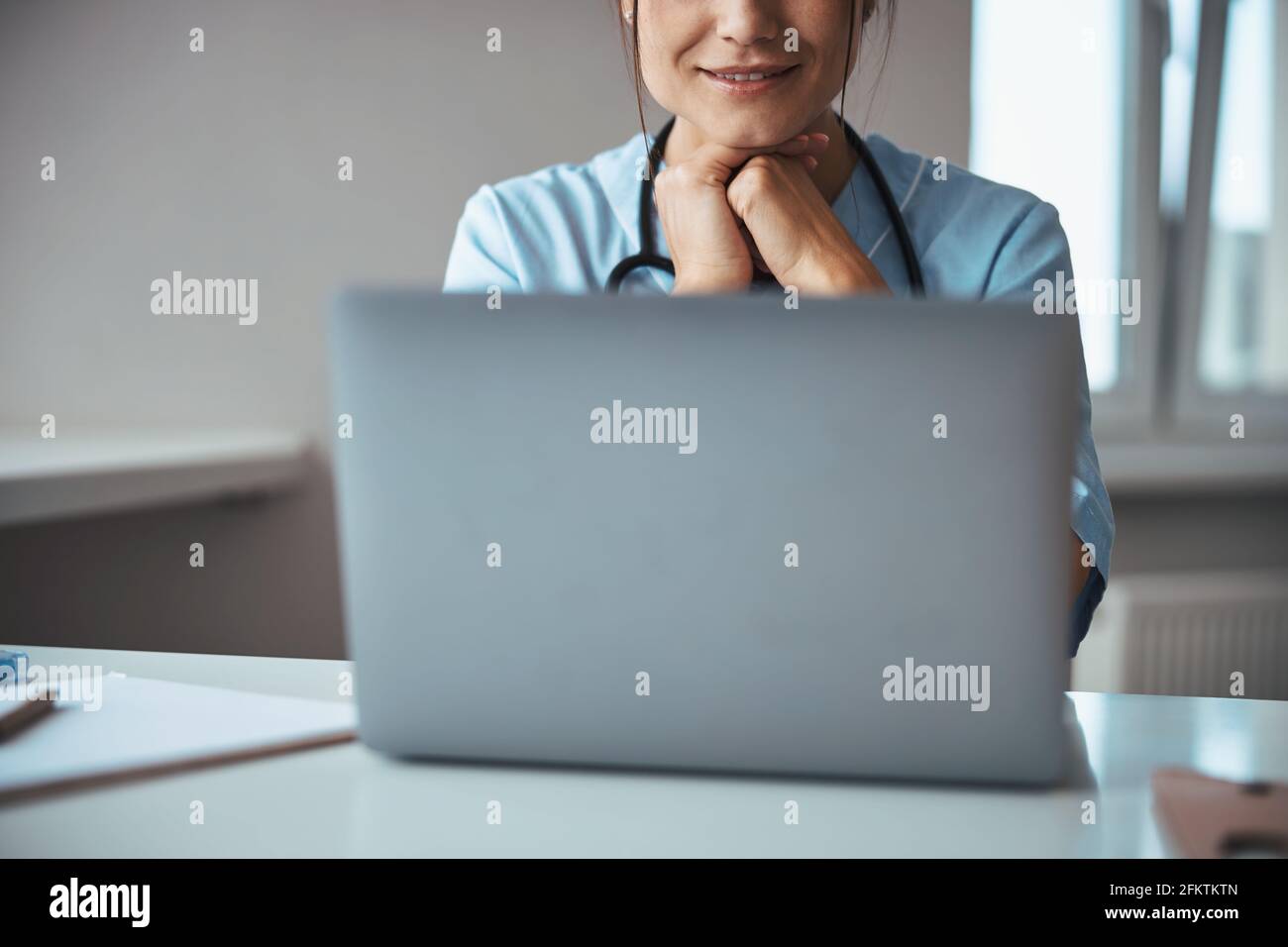 Smiling female doctor using laptop in clinic Stock Photo