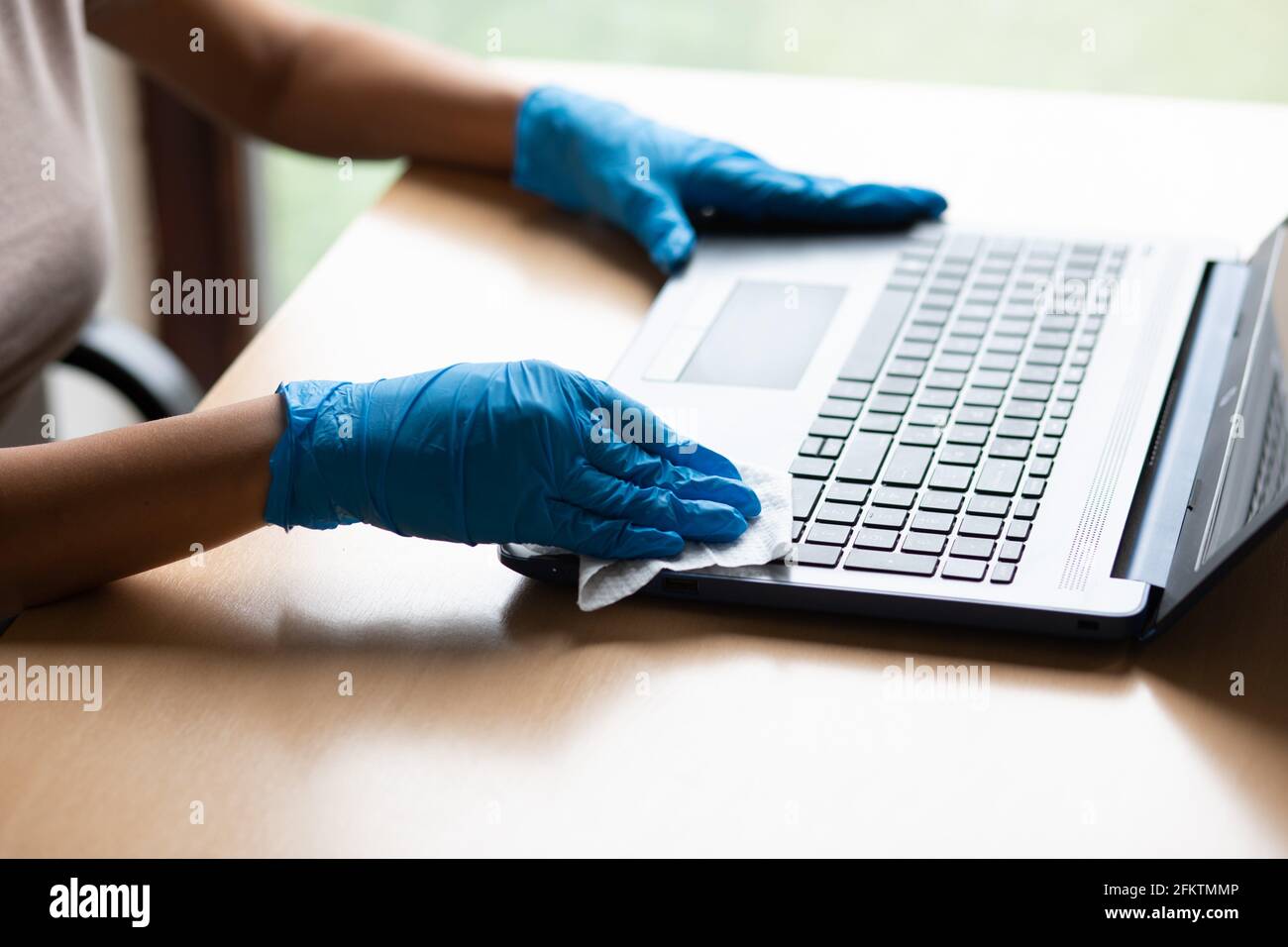 Work from home safe, cleaning and disinfecting laptop computer with wet
