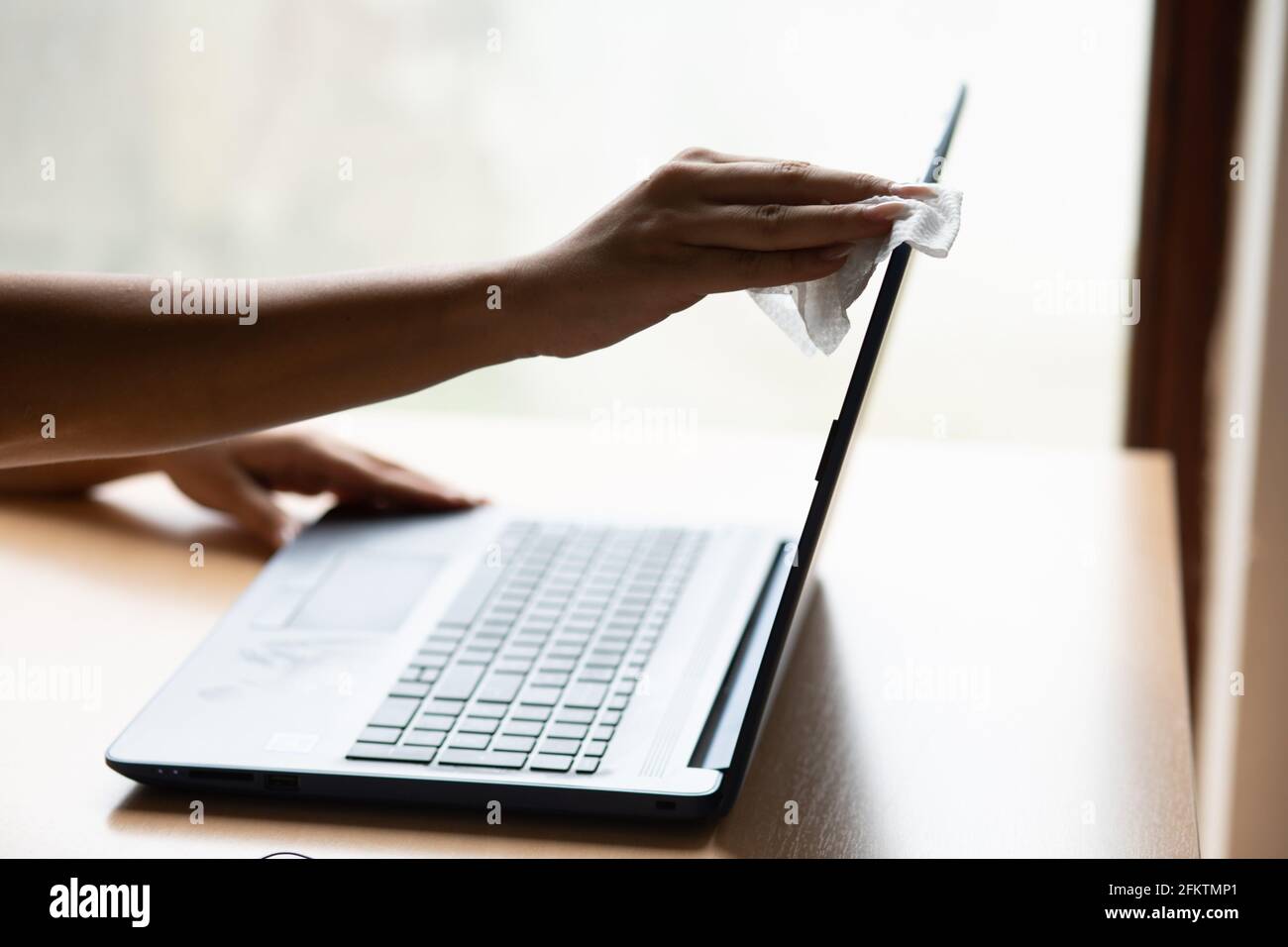 Work from home safe, cleaning and disinfecting laptop computer with wet