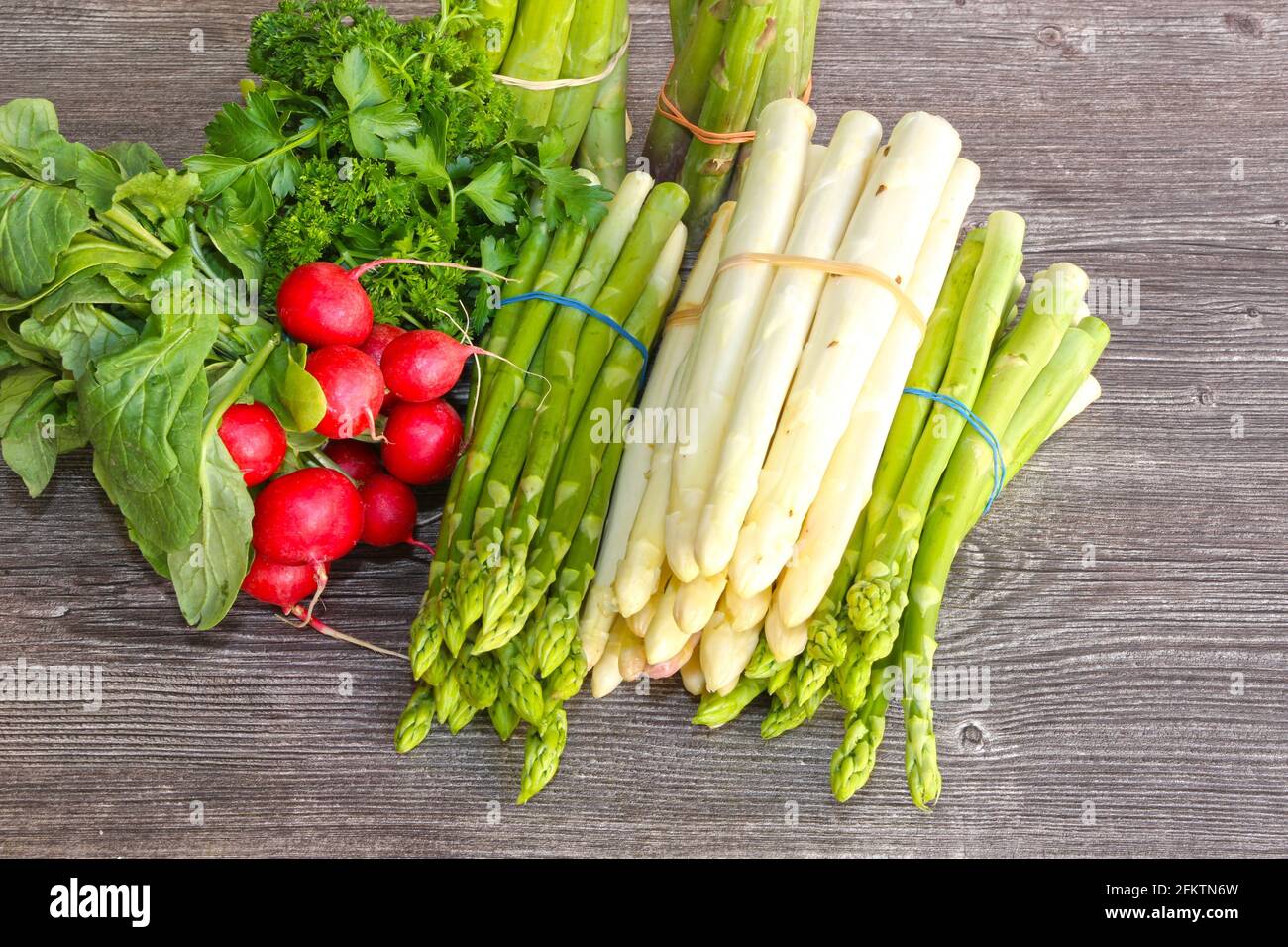 Green and white asparagus decorated on a rustic wooden table. Stock Photo