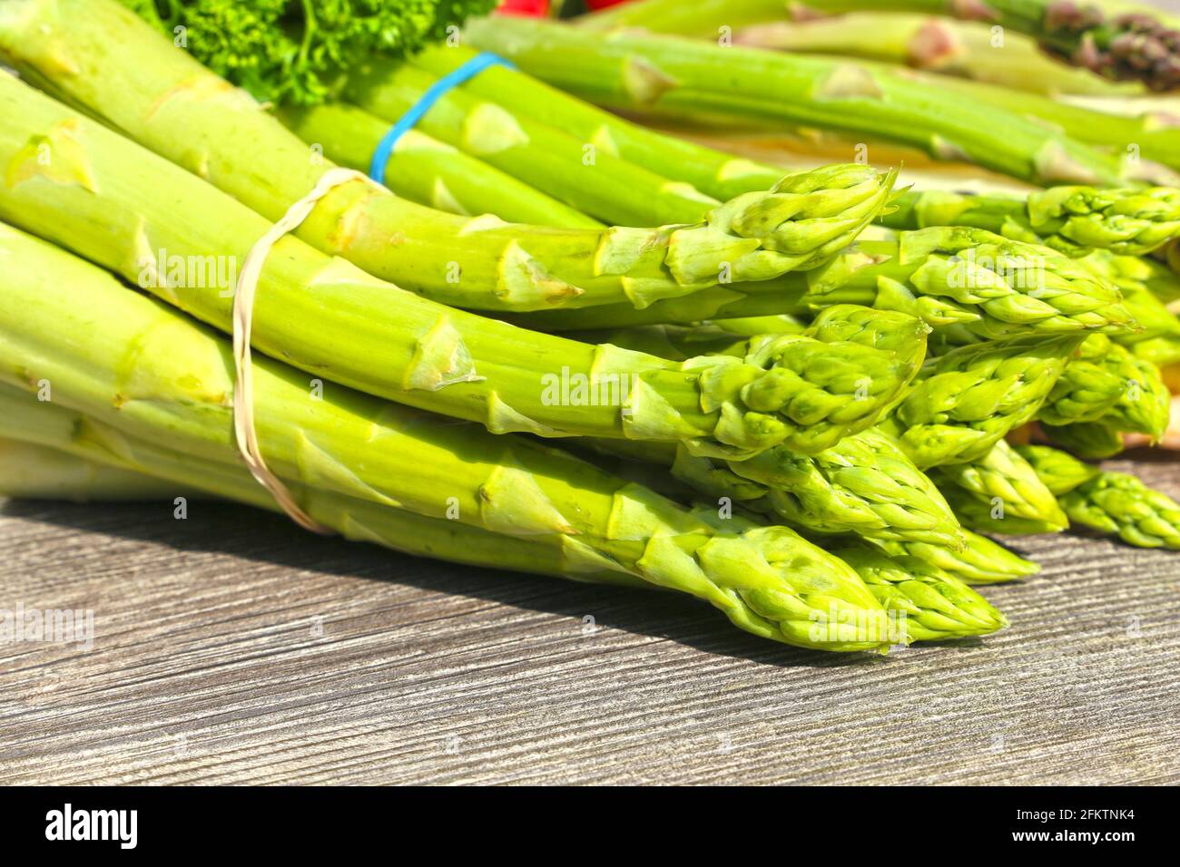 Green asparagus decorated on a rustic wooden table. Stock Photo