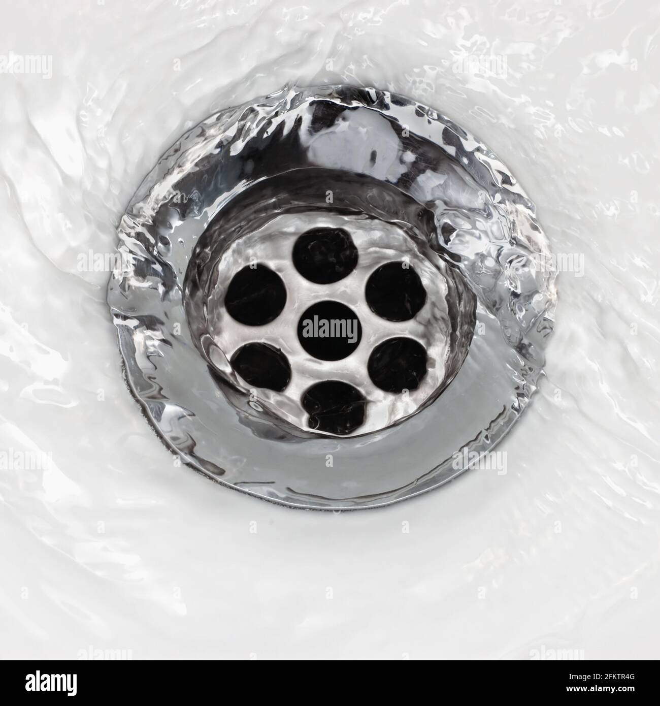 Sink plug drain hole bath plughole, white basin spout, running water macro closeup, stainless steel, china porcelain hand washbasin, large detailed Stock Photo