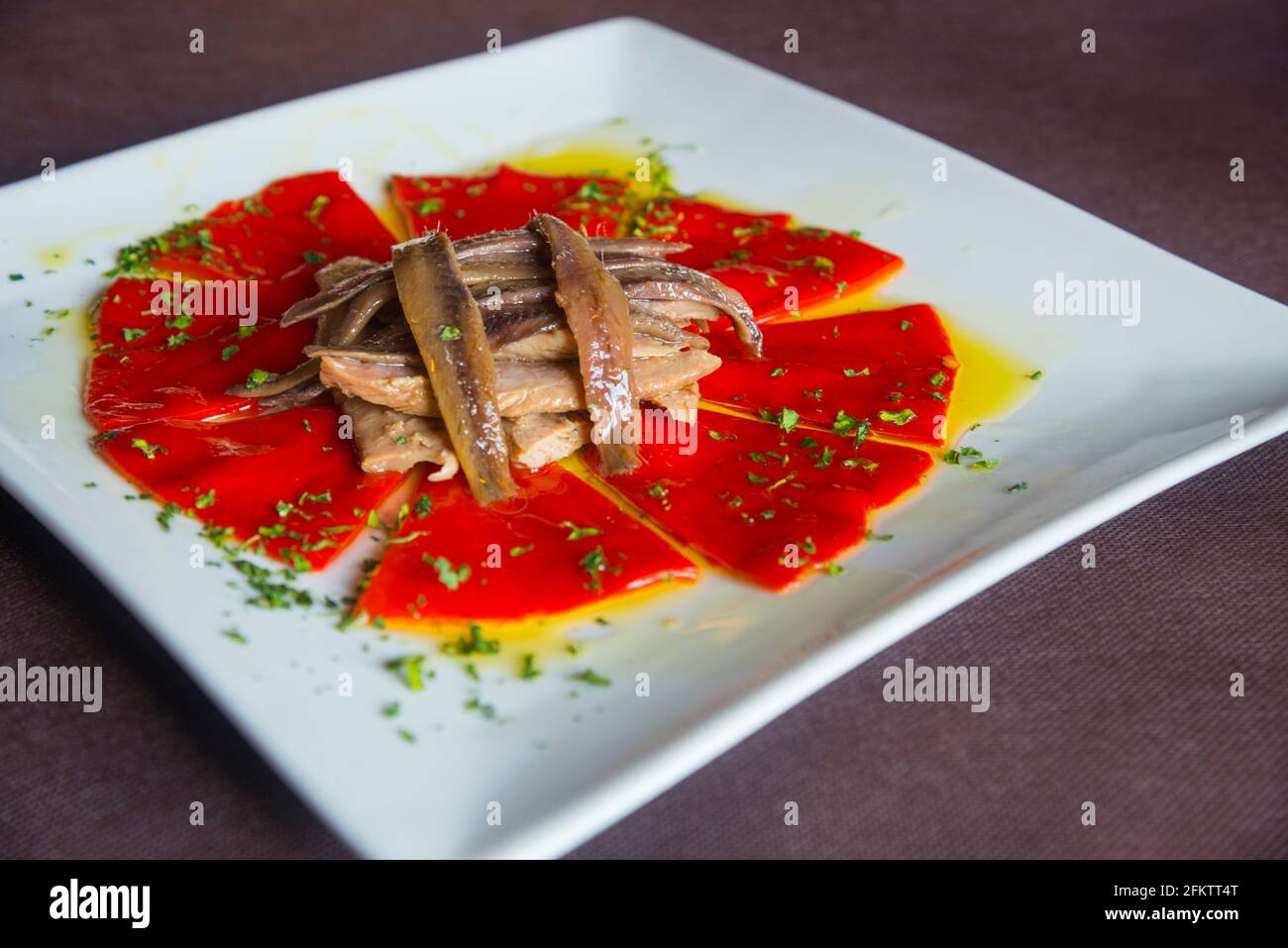 Salad made of Piquillo peppers, tuna loin, anchovy fillets, parsley and olive oil. Spain. Stock Photo