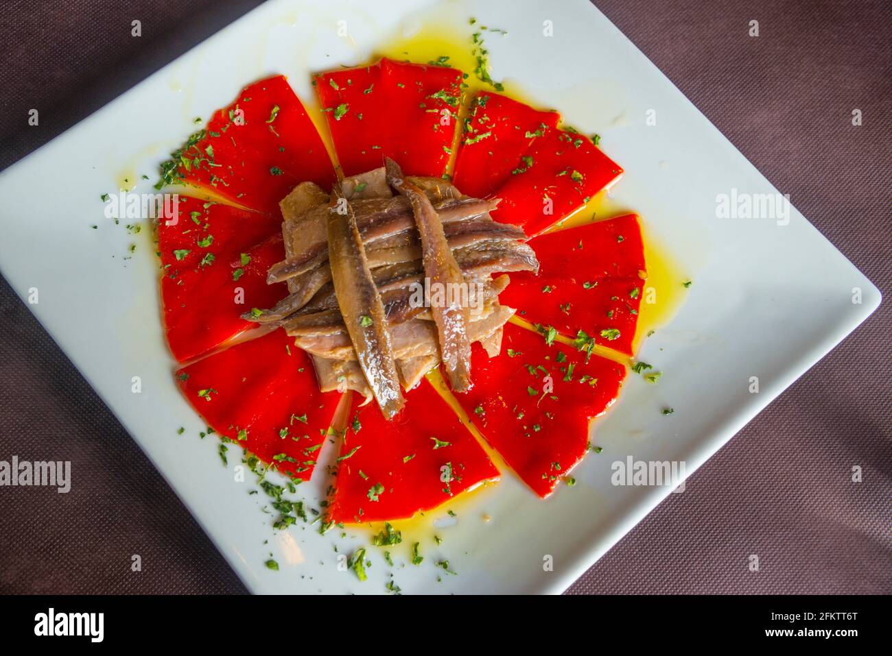 Salad made of Piquillo peppers, tuna loin, anchovy fillets, parsley and olive oil. Spain. Stock Photo