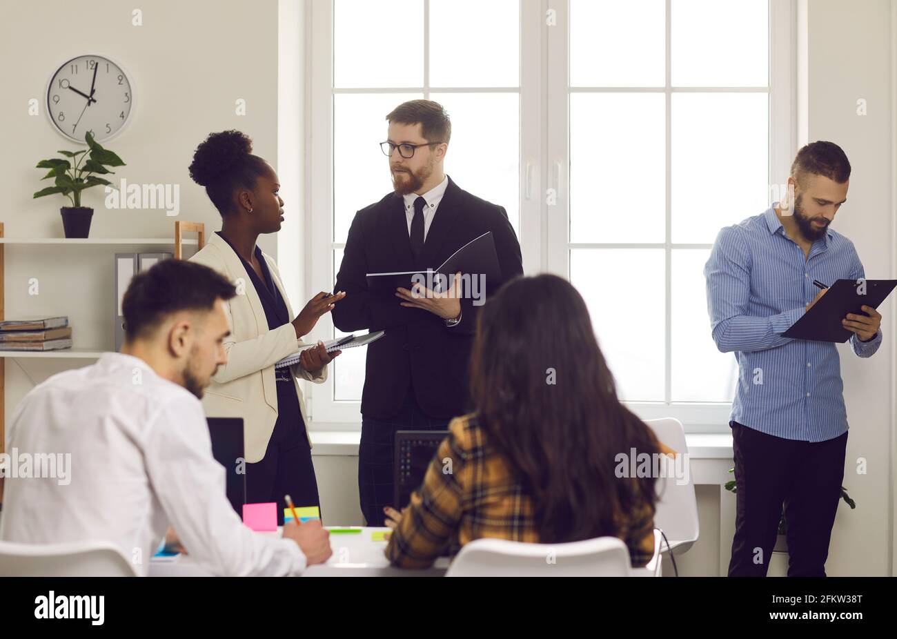 Group of international business people work and communicate in a coworking center. Stock Photo