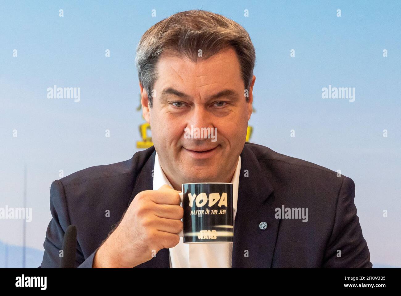 Munich, Germany. 04th May, 2021. Markus Söder (CSU), Prime Minister of Bavaria, drinks from a Star Wars mug with the inscription 'Yoda - Master of the Jedi' before the start of the meeting of the Bavarian cabinet, which is being conducted as a video conference. Credit: Peter Kneffel/dpa/Alamy Live News Stock Photo