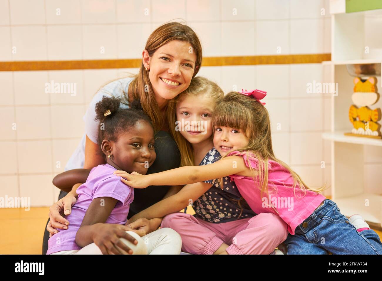 Happy childminder and children in international kindergarten for integration concept Stock Photo