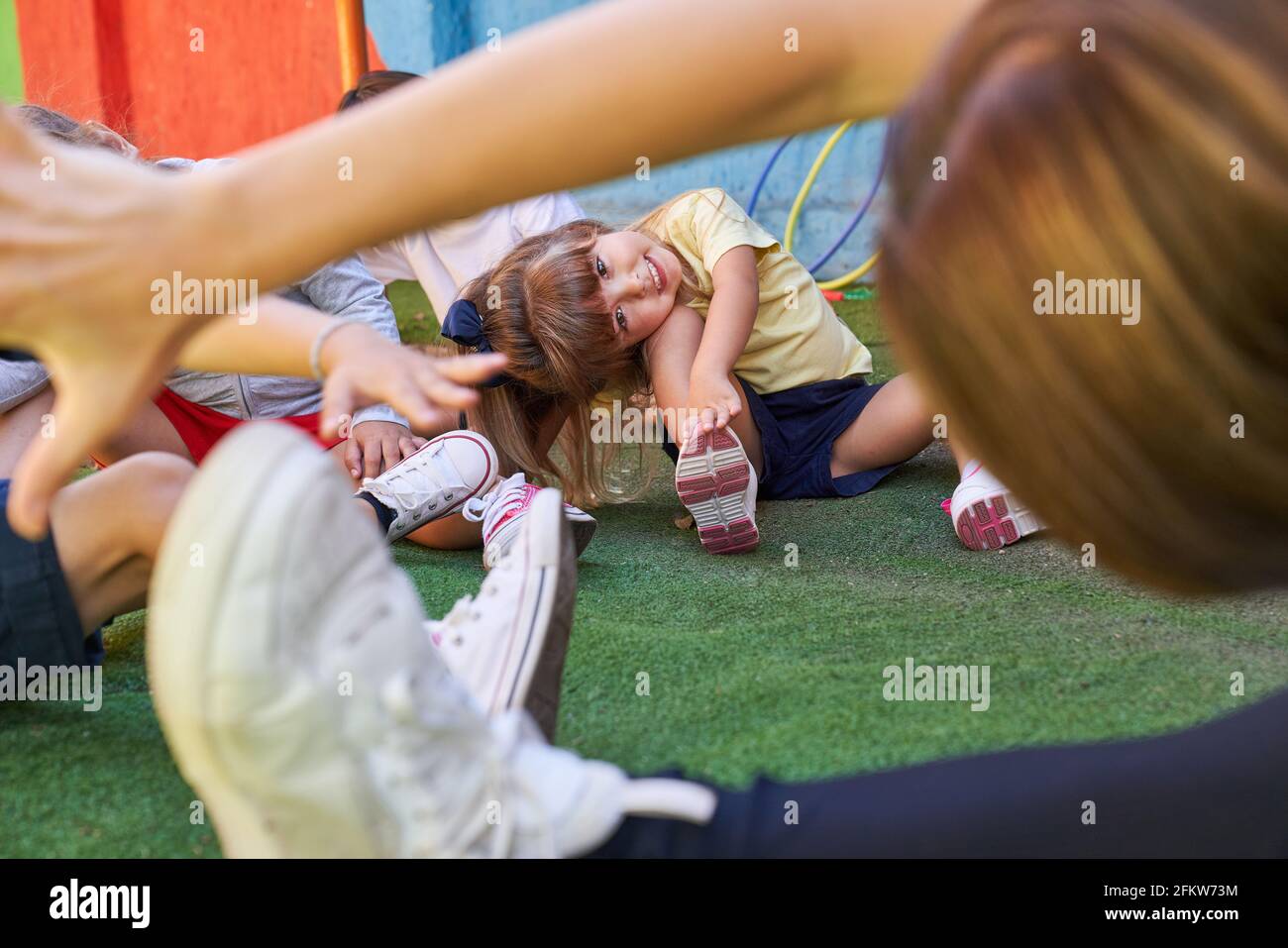 Children group and gym teacher have fun stretching in physical education class in kindergarten Stock Photo