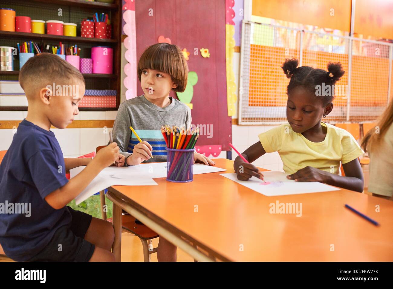 Group of multicultural children painting pictures in creative painting