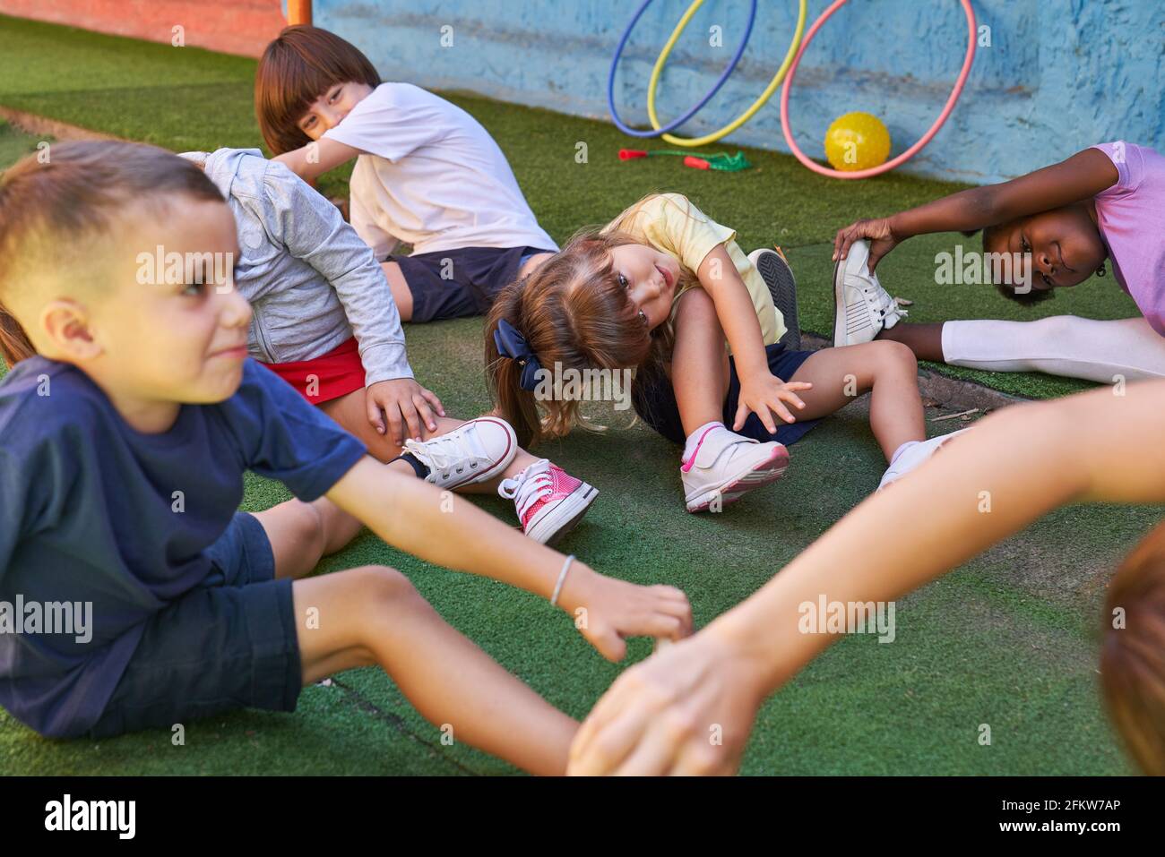 Group of children doing children's gymnastics together with an educator in the day care center Stock Photo