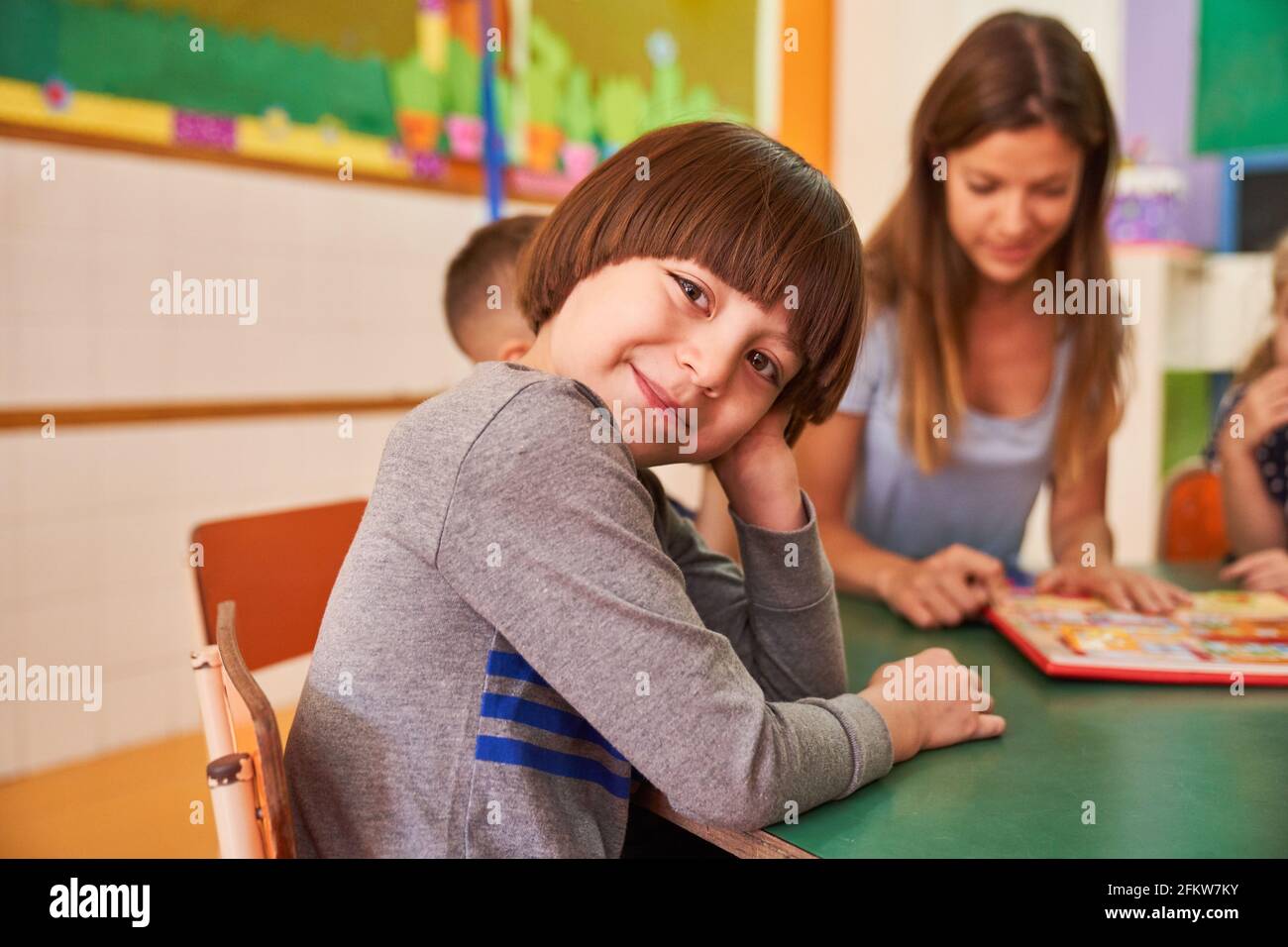 Happy boy in kindergarten or after-school care center playing with other children Stock Photo