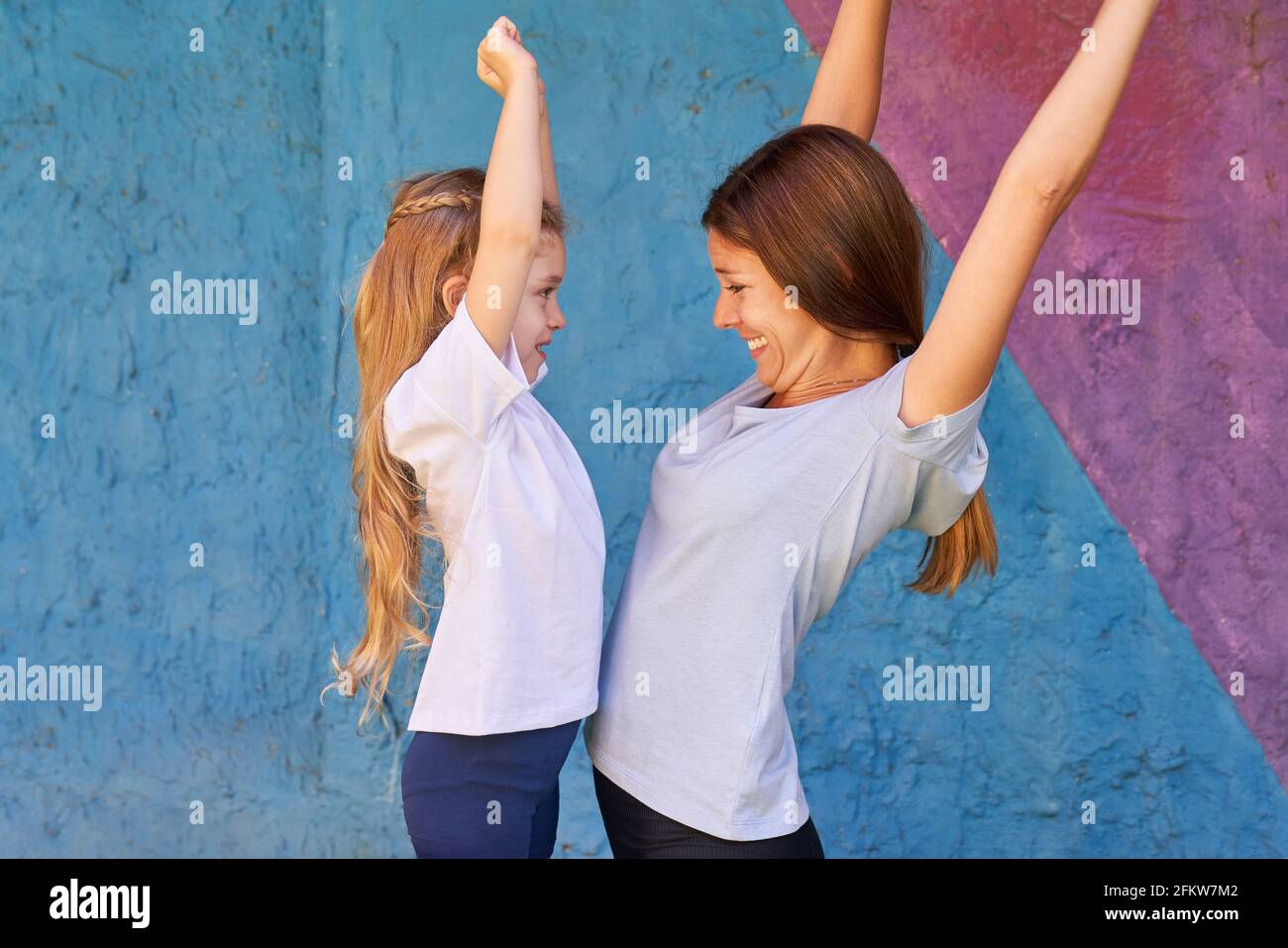 Gym teacher and girl do gymnastics together during children's gymnastics in preschool Stock Photo