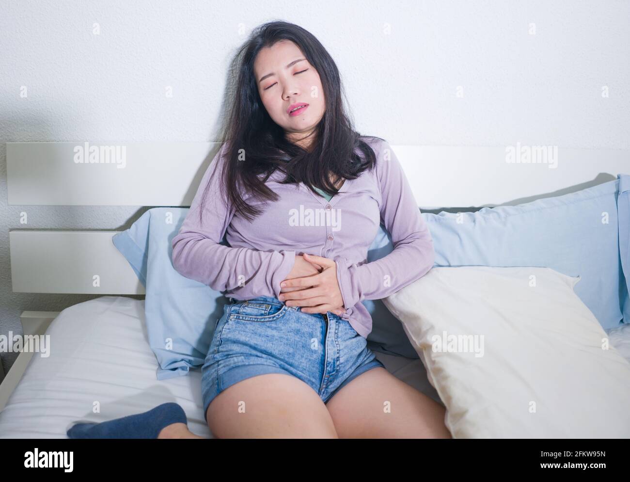 young Asian woman suffering menses abdominal cramp sick and tired